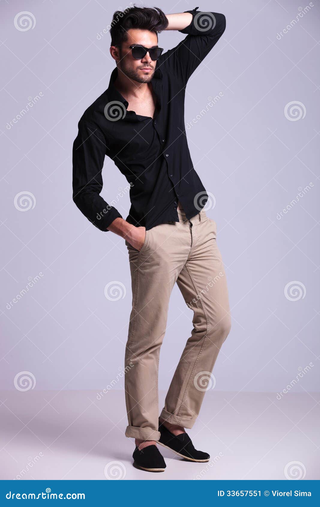 young fashion man poses hand hair full length picture standing his one his pocket looking away 33657551