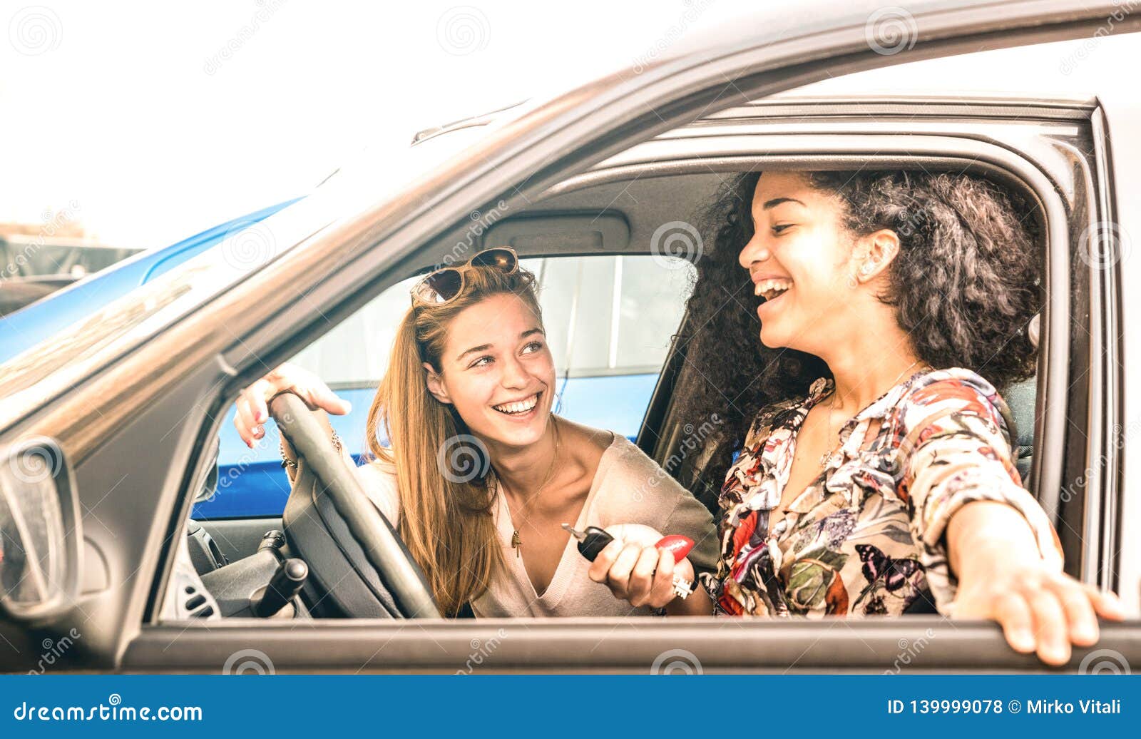 young female best friends having fun at car roadtrip moment - transportation concept and urban ordinary life