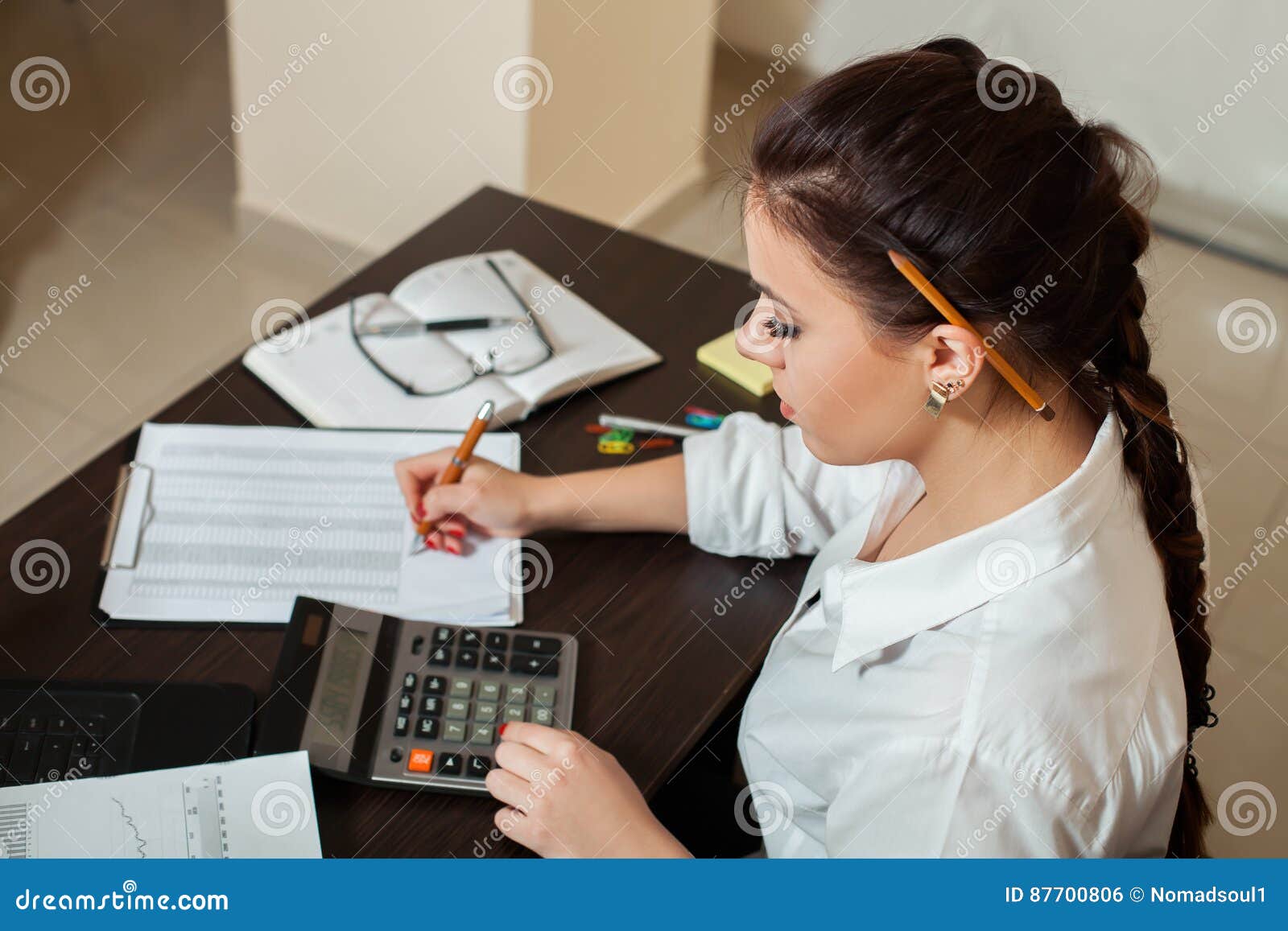 young female bookkeeper considers on calculator