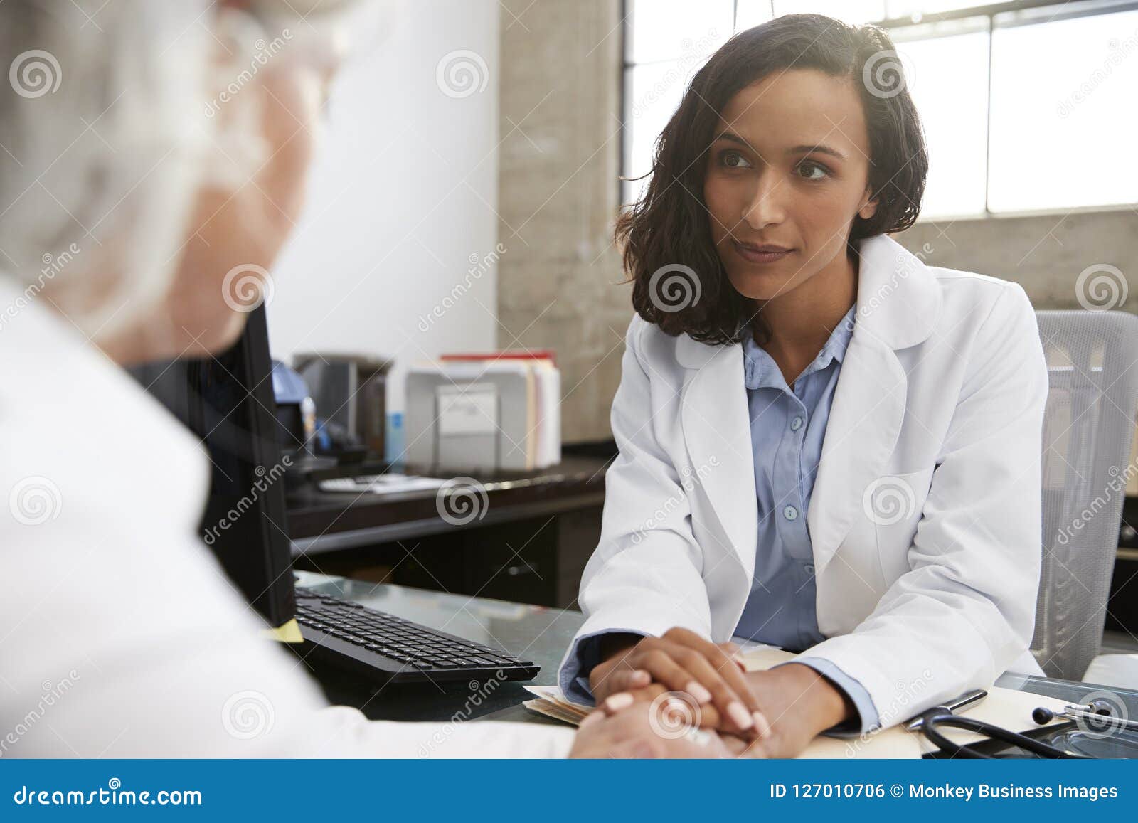 young female doctor in consultation with senior patient
