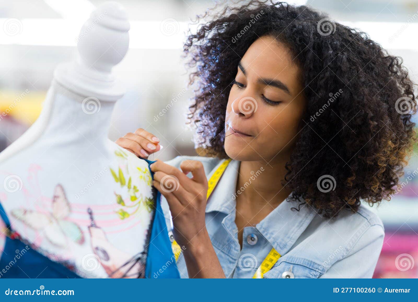 Young Female Dressmaker Pinning and Adjusting Tissue on Dummy Stock