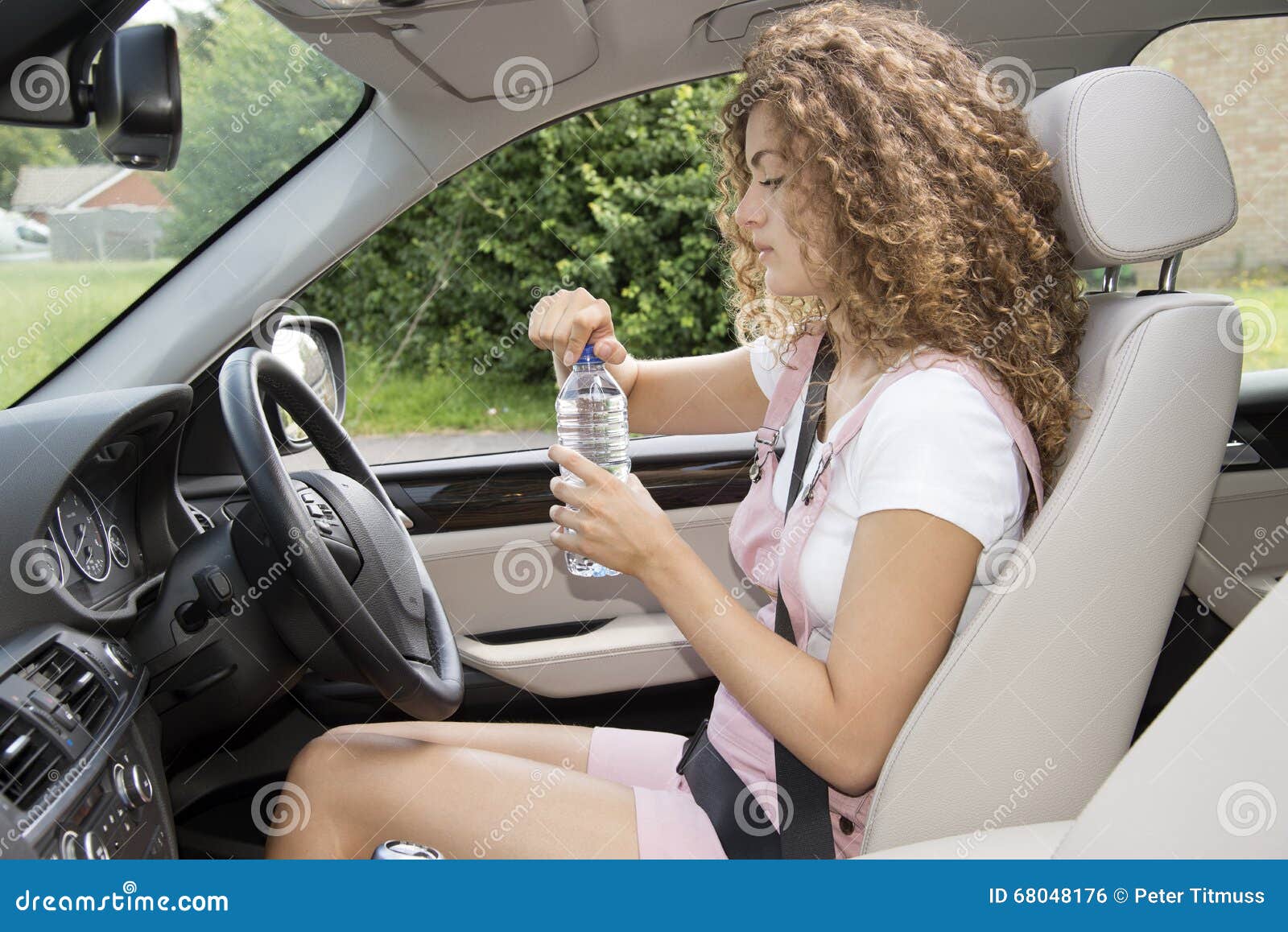 Young Female Driver Drinking from a Bottle of Water Stock Photo Image