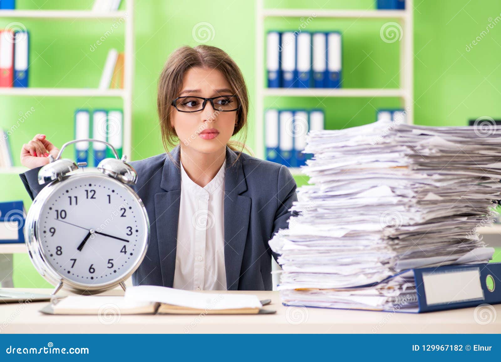 young female employee very busy with ongoing paperwork in time m