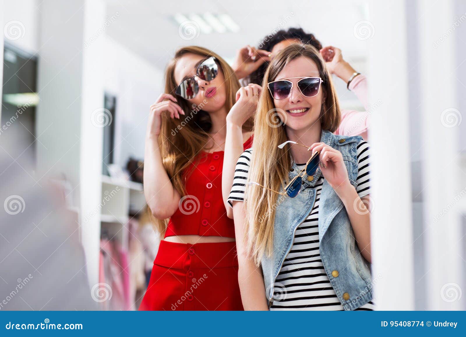 Young Female Friends Trying on Sunglasses Laughing and Having Fun in ...