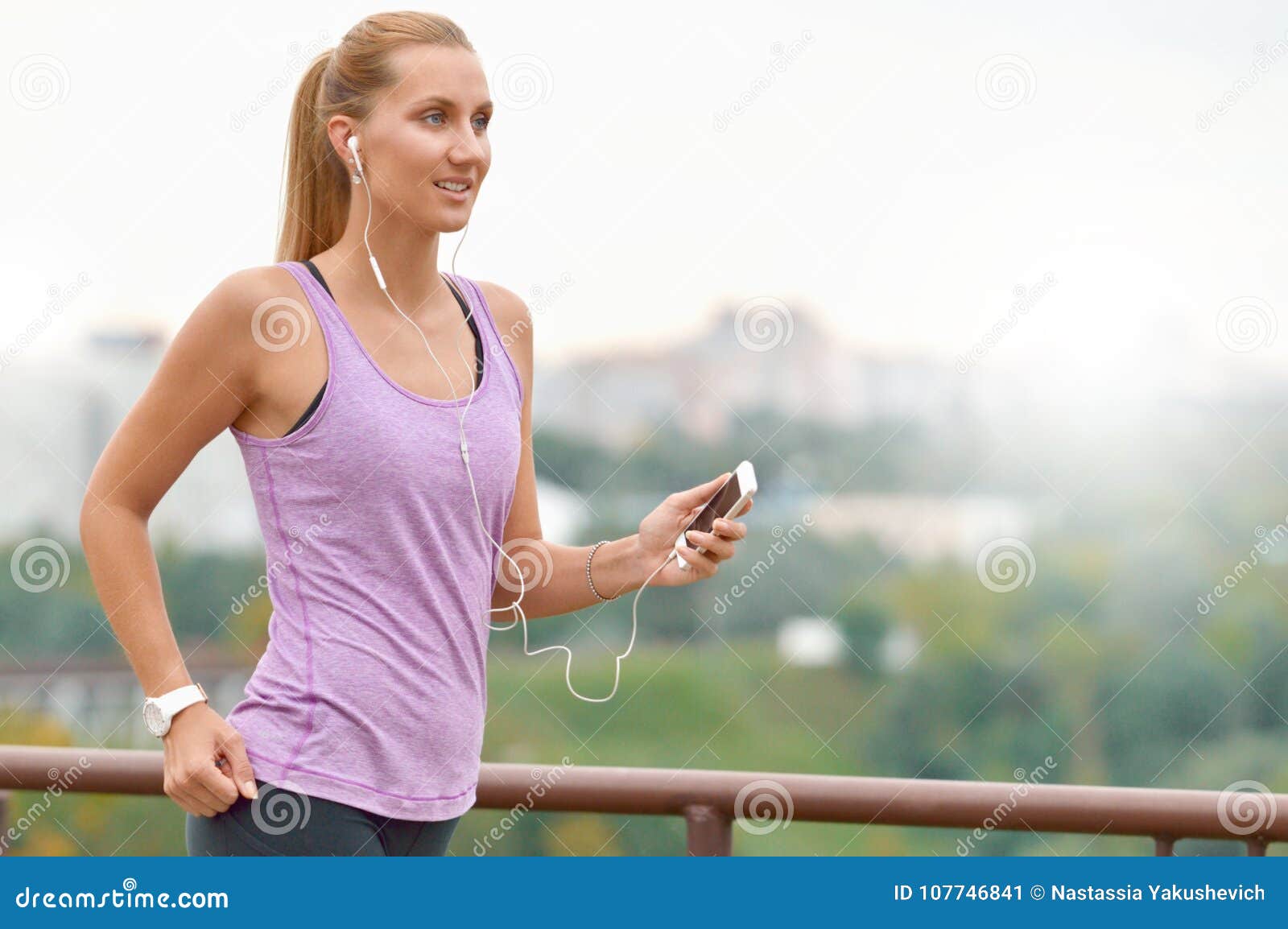 young female joger is runing and listening to music during the run