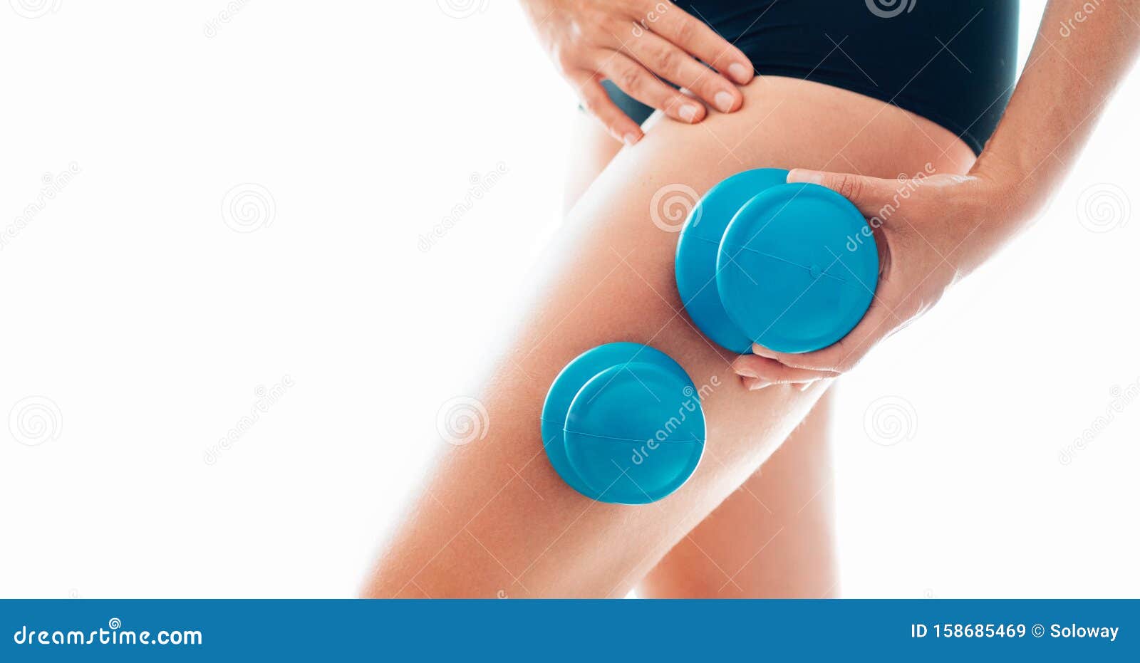 young female making massage using a two silicone cups for vacuum cupping anti-cellulite massage therapy on her thigh zone skin