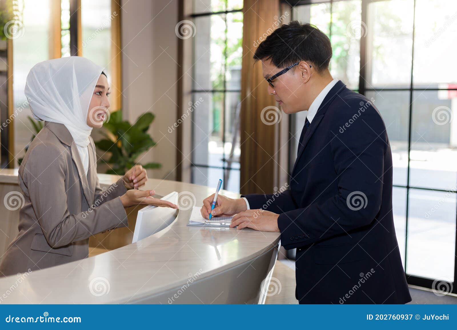 young female muslim receptionists are introducing hotel stays to travelers