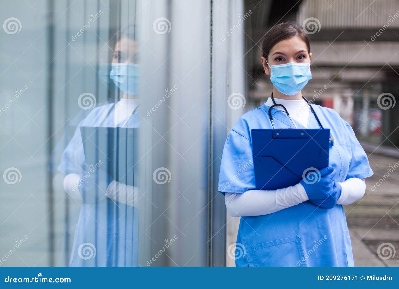 young female nhs uk ems doctor in front of healthcare icu facility