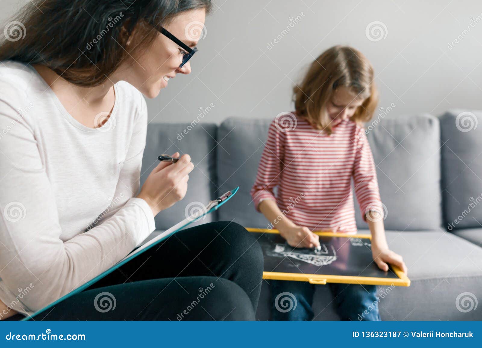 young female psychologist talking with patient child girl in office. mental health of children