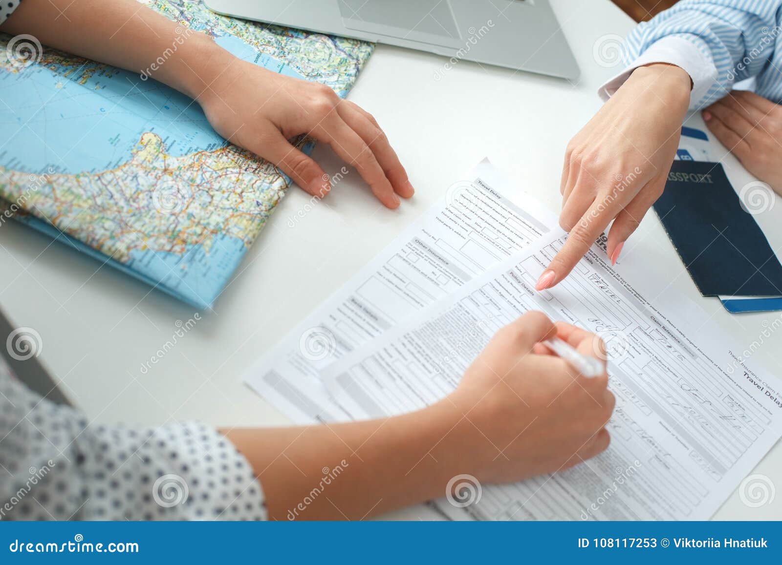 young female travel agent consultant in tour agency with a customer signing documents