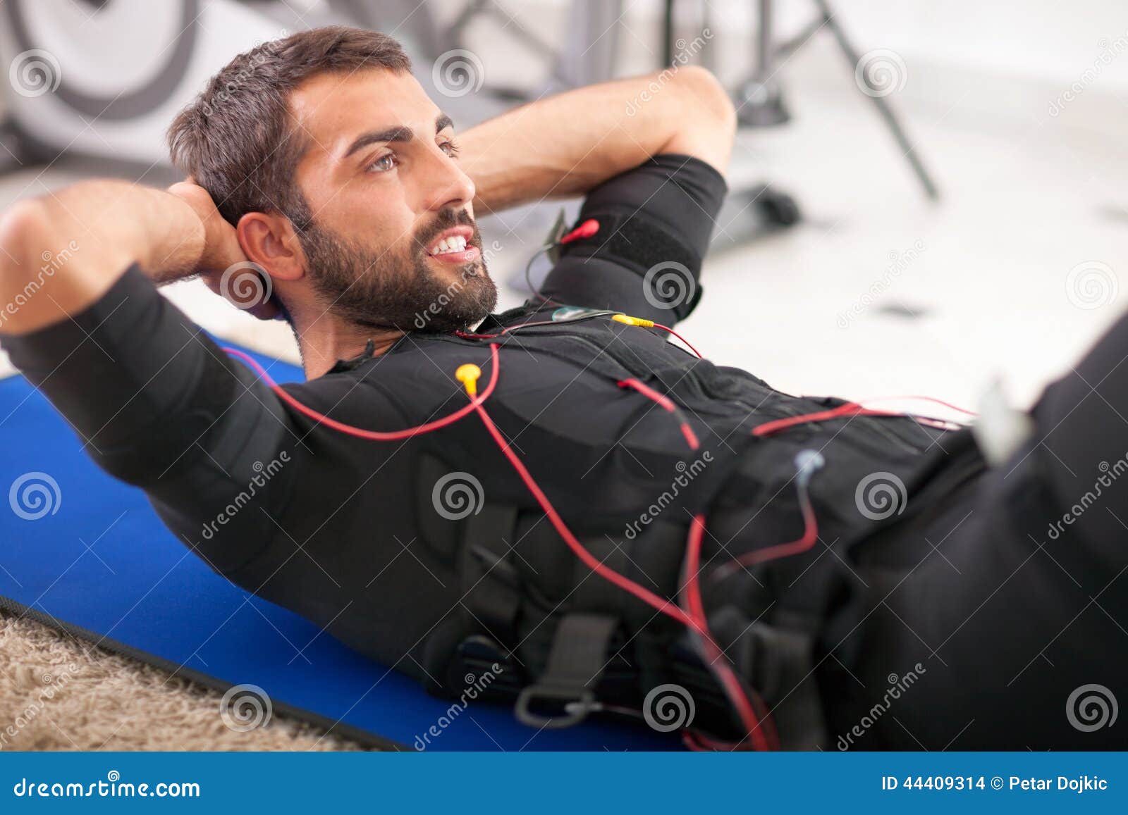 Young Fit Man Exercise on Electro Muscular Stimulation Machine Stock