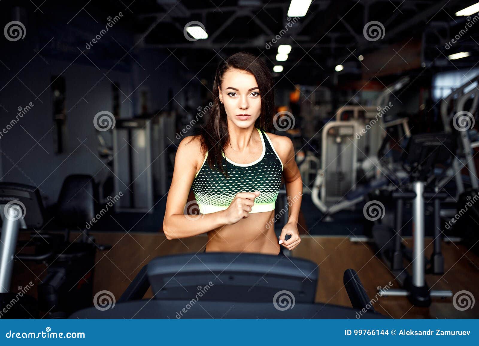 young fitness woman doing cardio exercises at the gym running on a treadmill.
