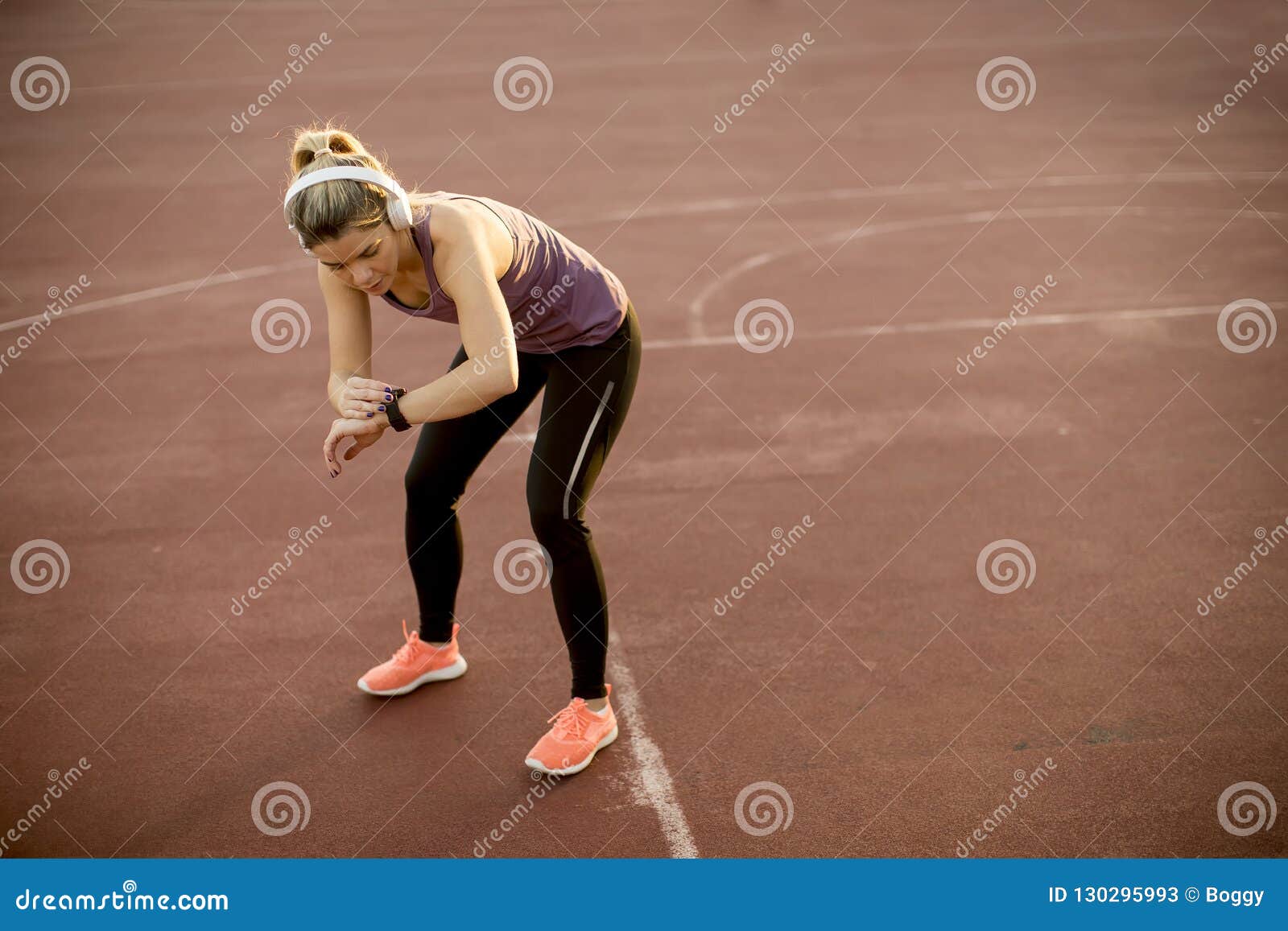 Happy female athlete wearing sports wear and checking her pulse rate with  smartwatch while outdoors exercising stock photo (267345) - YouWorkForThem