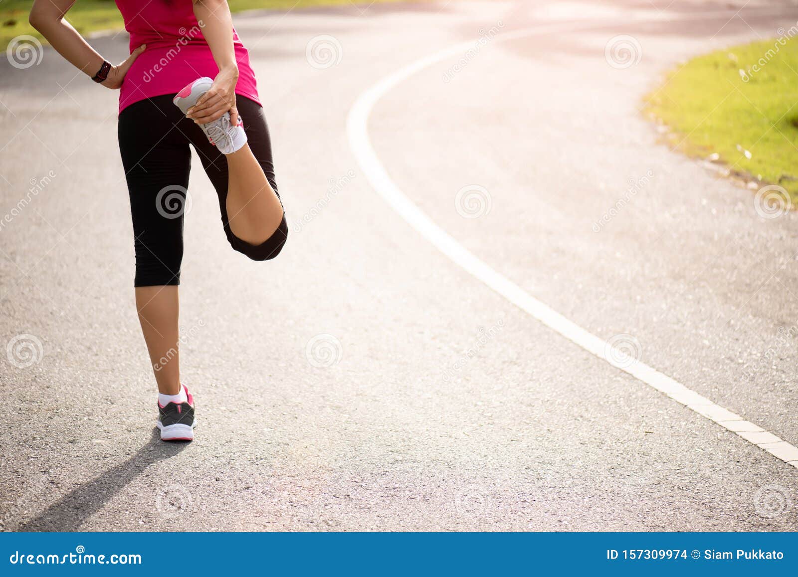 Young Fitness Woman Runner Stretching Legs Before Run In The Park