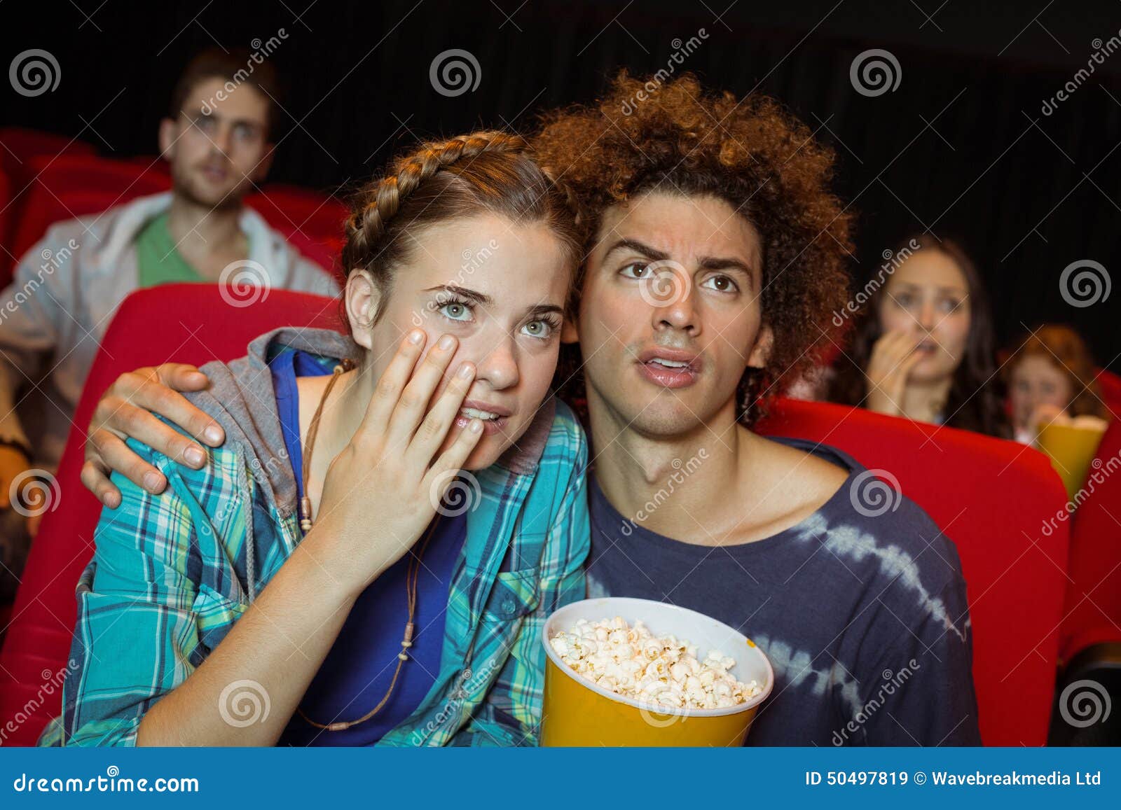 Young friends watching a film at the cinema