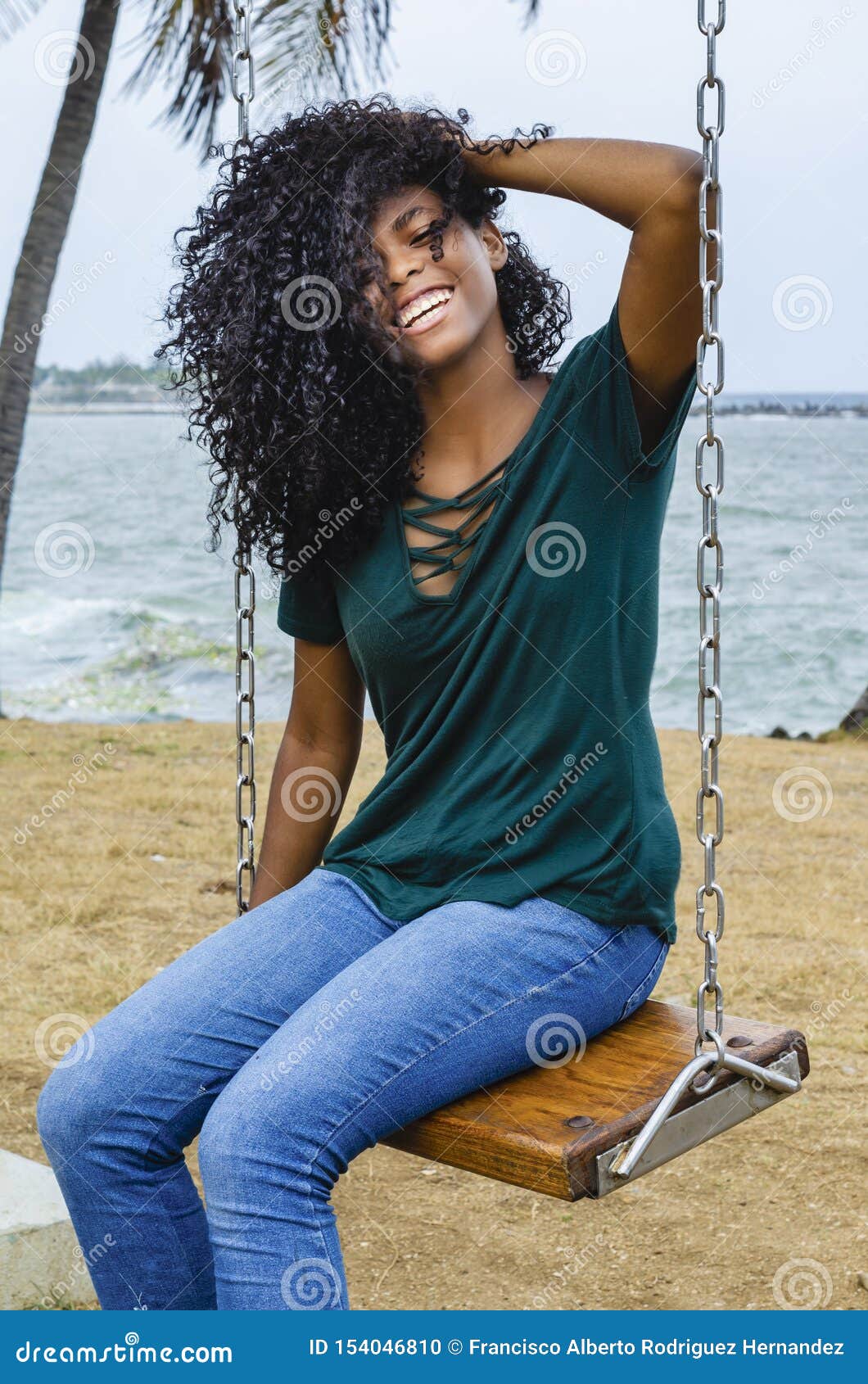 Young Girl with Black Hair, Laughing Hair Sitting on a Back Swing To the Caribbean Sea, Enjoying a Summer Day with the Wind in Her Stock Photo - Image of scene, attractive: Young Girl with Black Hair, Laughing Hair Sitting on a Back Swing To the Caribbean Sea, Enjoying a Summer Day with the Wind in Her Stock Photo - Image of scene, attractive: