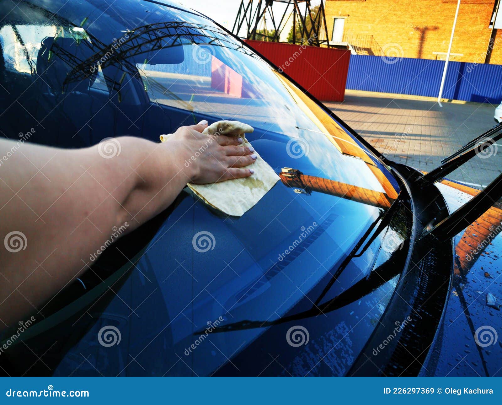 A Young Girl at a Car Wash, Washes the Car Using a Microfiber Cloth
