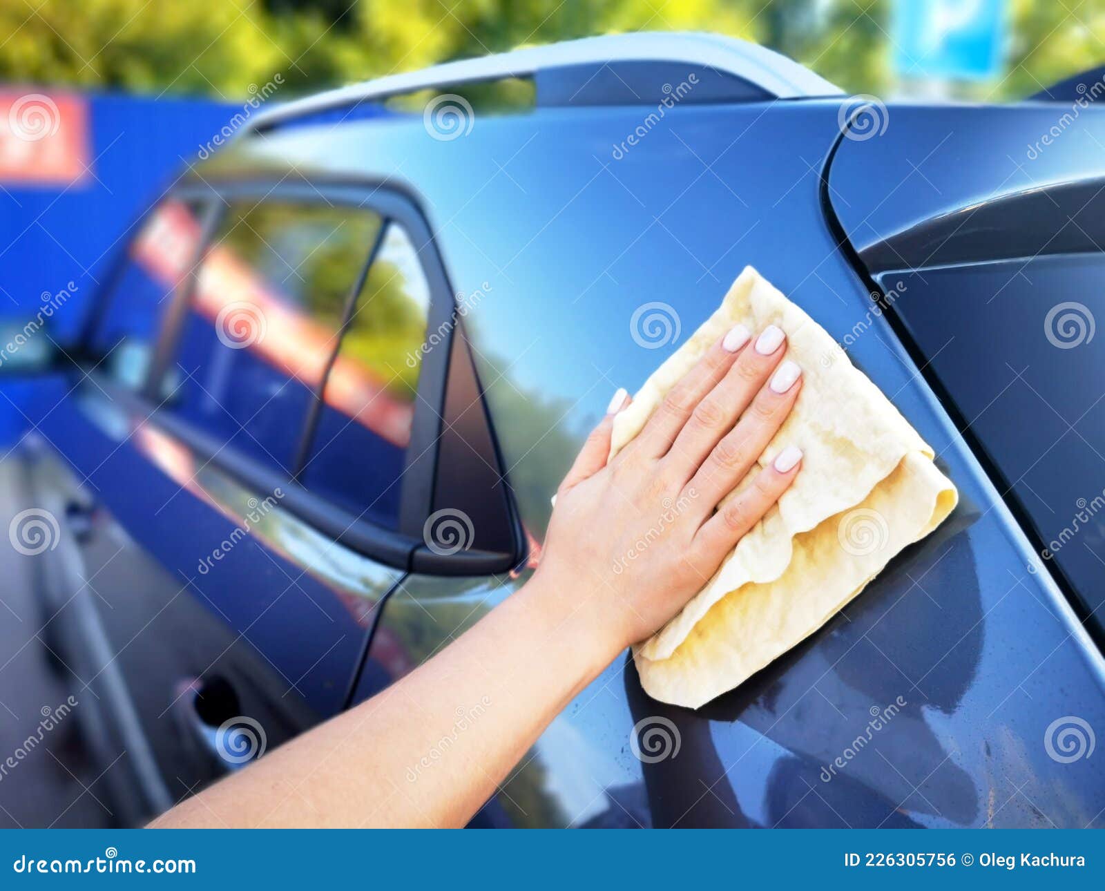 A Young Girl at a Car Wash, Washes the Car Using a Microfiber Cloth