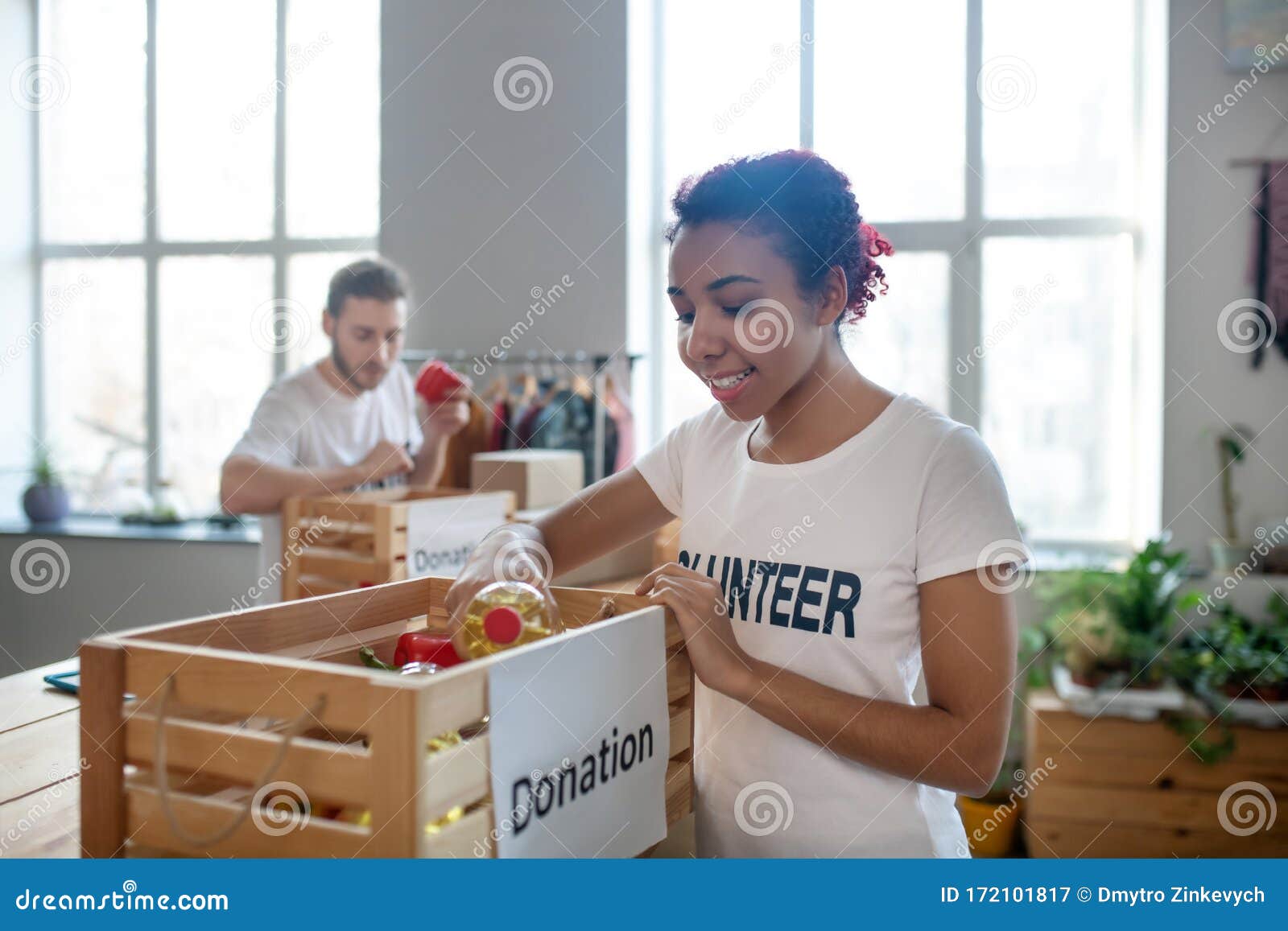Young Girl With Colored Hair Putting Vegetable Oil In Charity Box