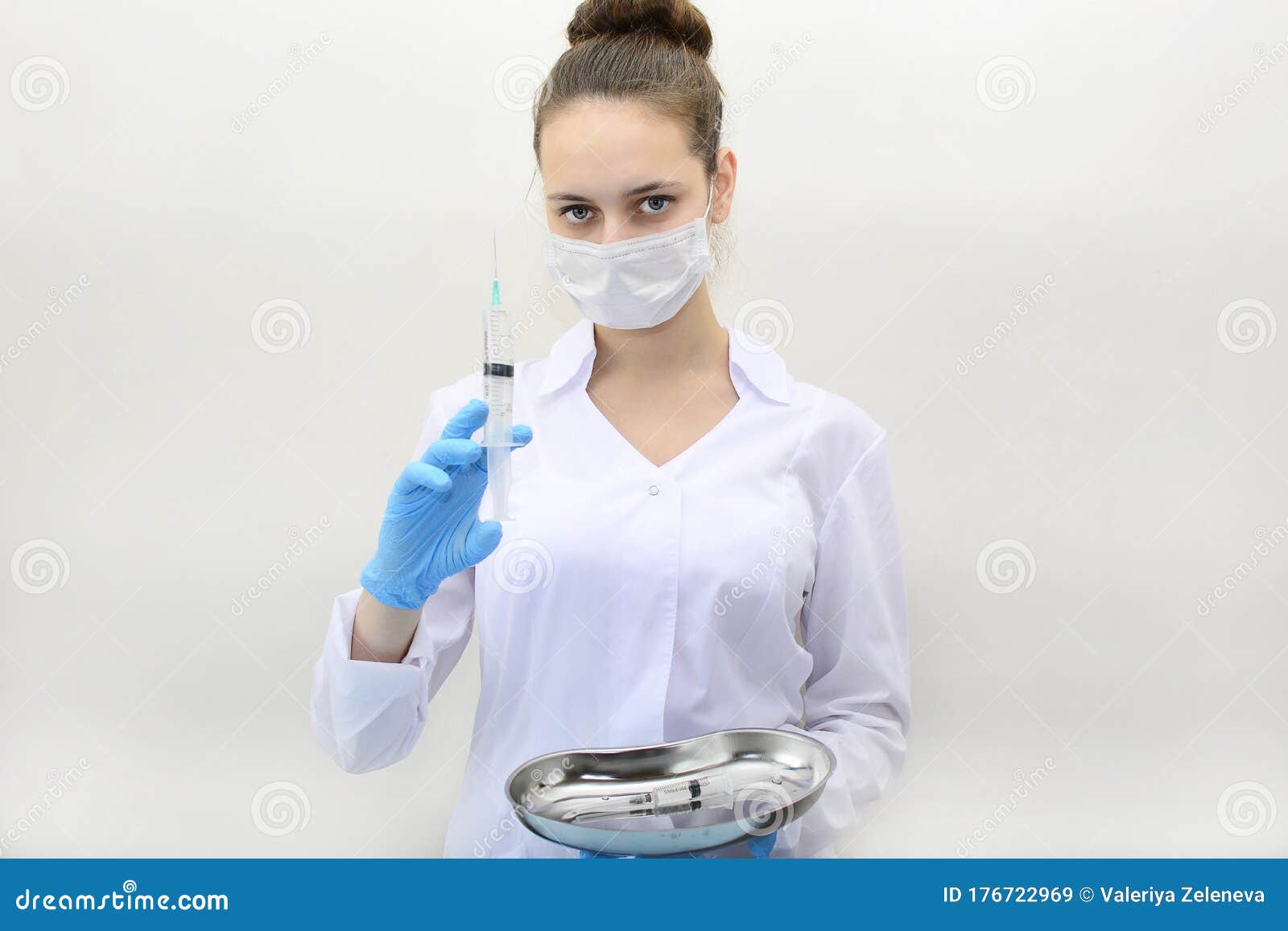 Young Girl Doctor in a Medical Mask and Blue Gloves Holds a Syringe ...
