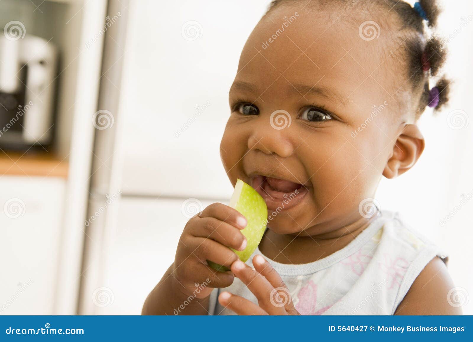 young girl eating apple indoors