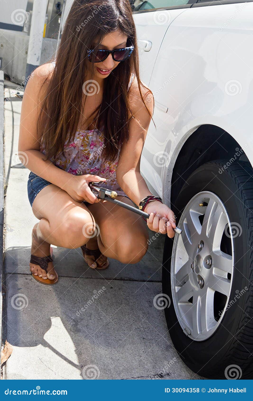 young-girl-gets-ready-to-add-air-to-car-tire-30094358.jpg