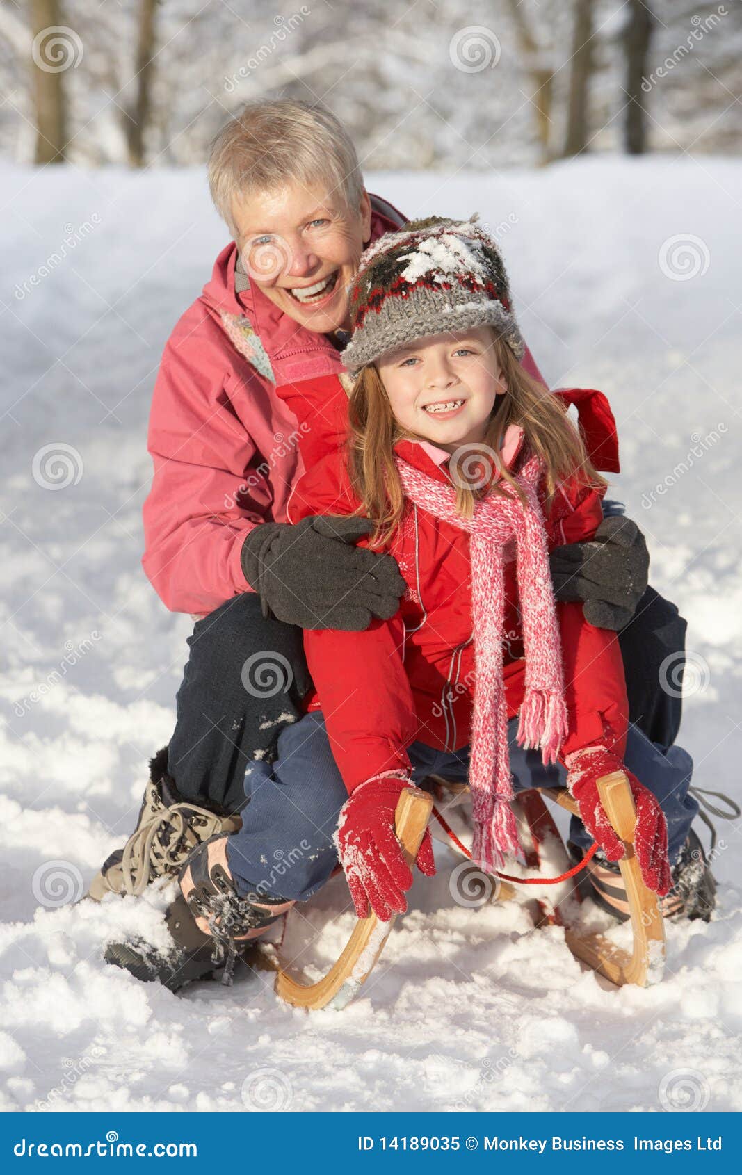 young girl with grandmother riding on sledge