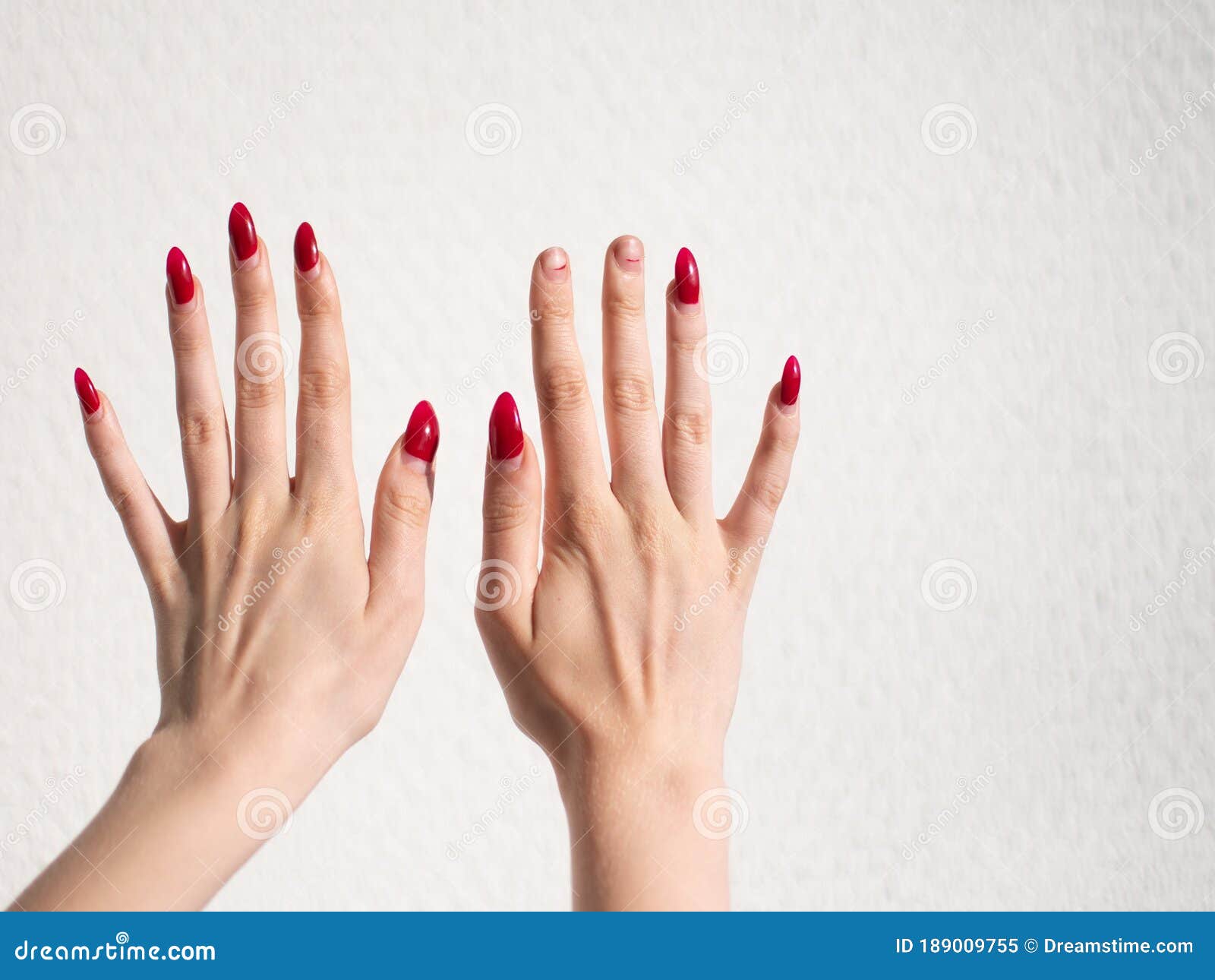 A Young Girl Had Red Manicured Nails On Two Of Her Hands And Two Of Her