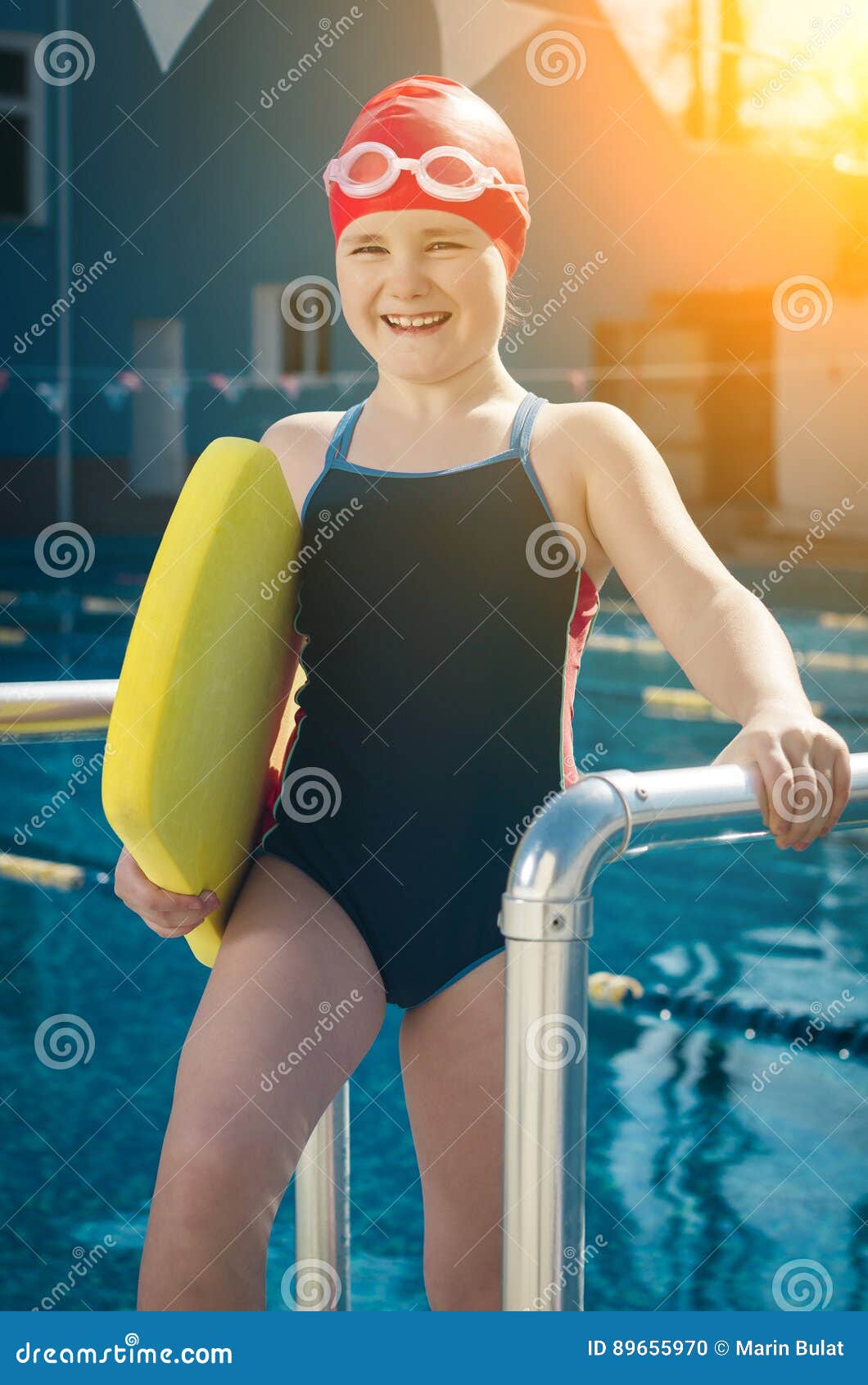 Young Girl Learning To Swim in the Pool with a Foam Board Stock Photo