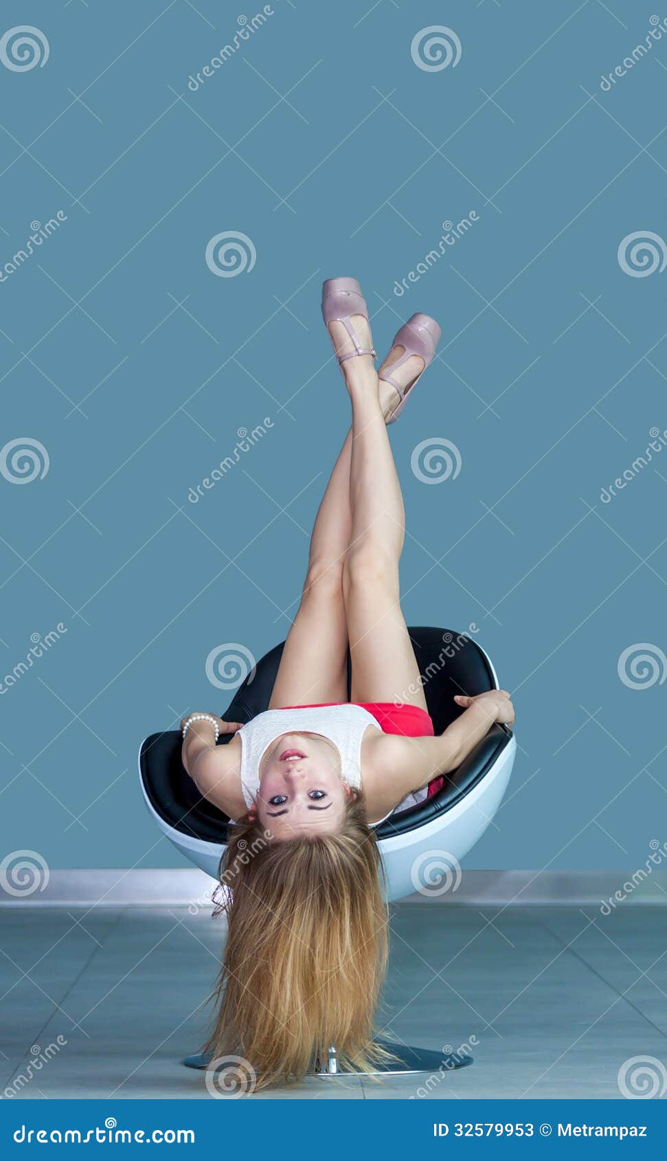 young girl lying on chair upside down