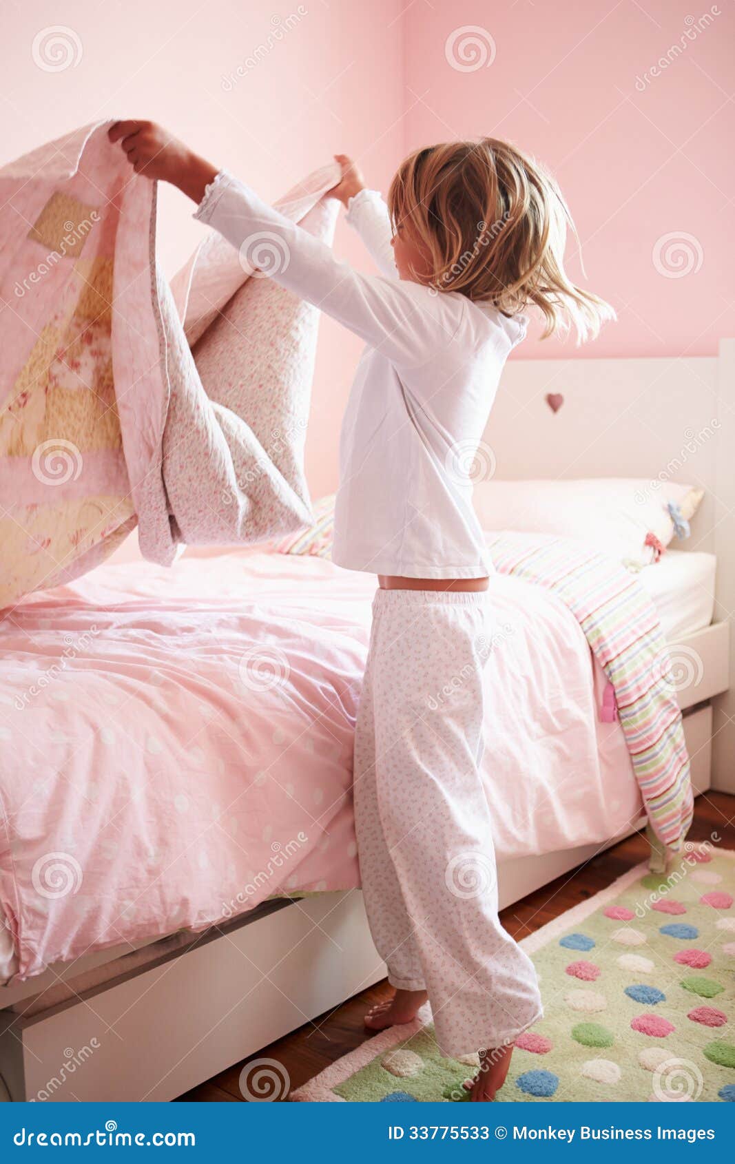 young girl making her bed