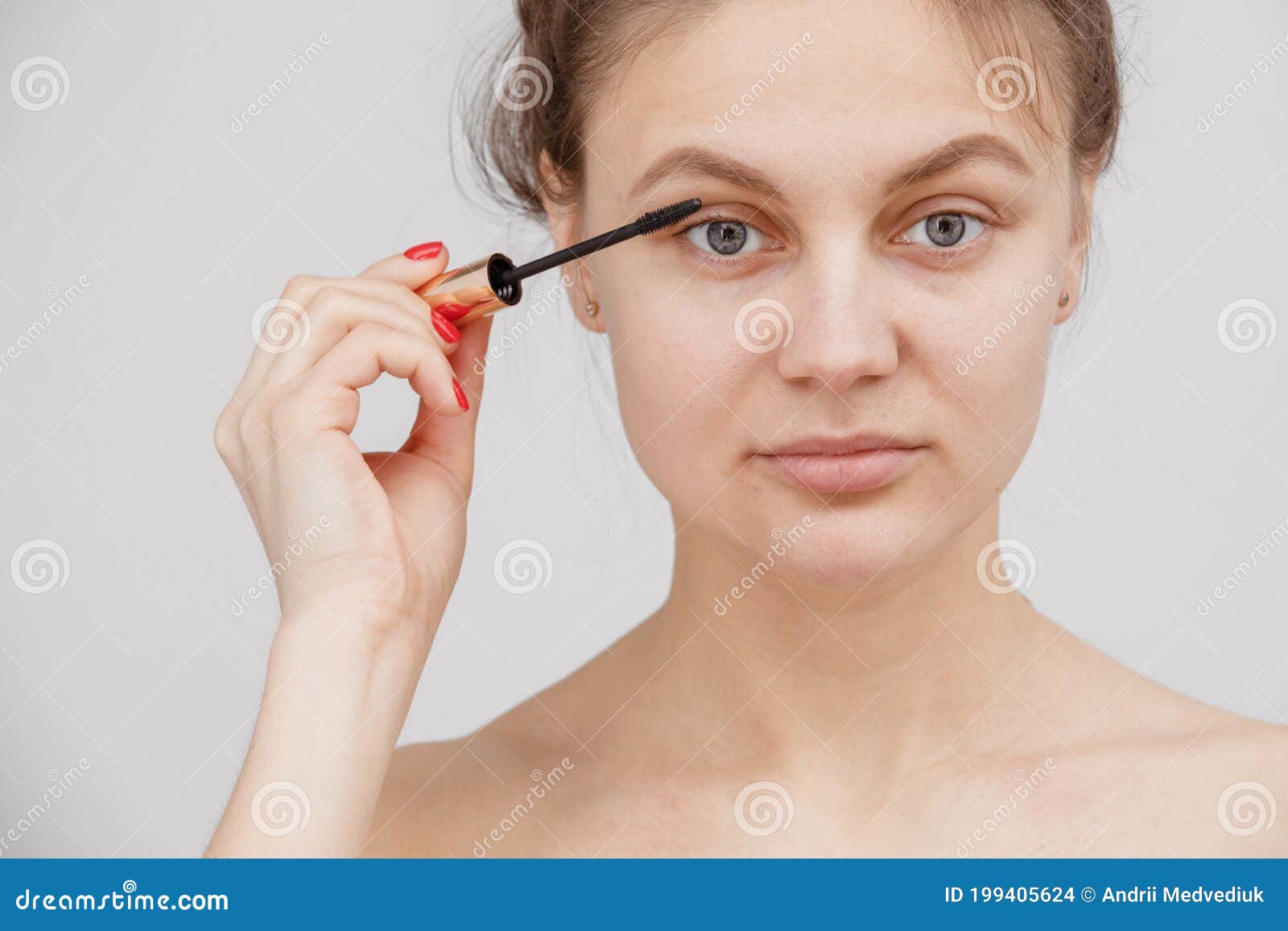 a young girl paints her eyelashes with mascara. face close-up. facial care