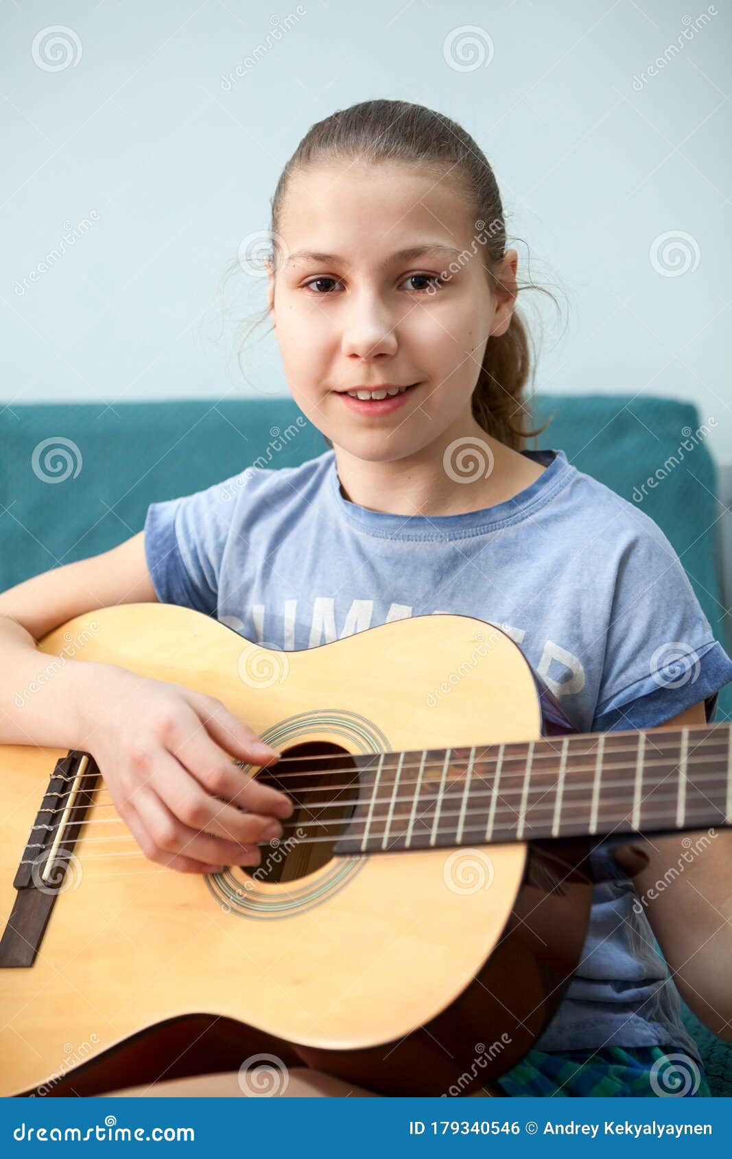 young girl quitarist portrait with aqoustic quitar, smiling and looking at camera