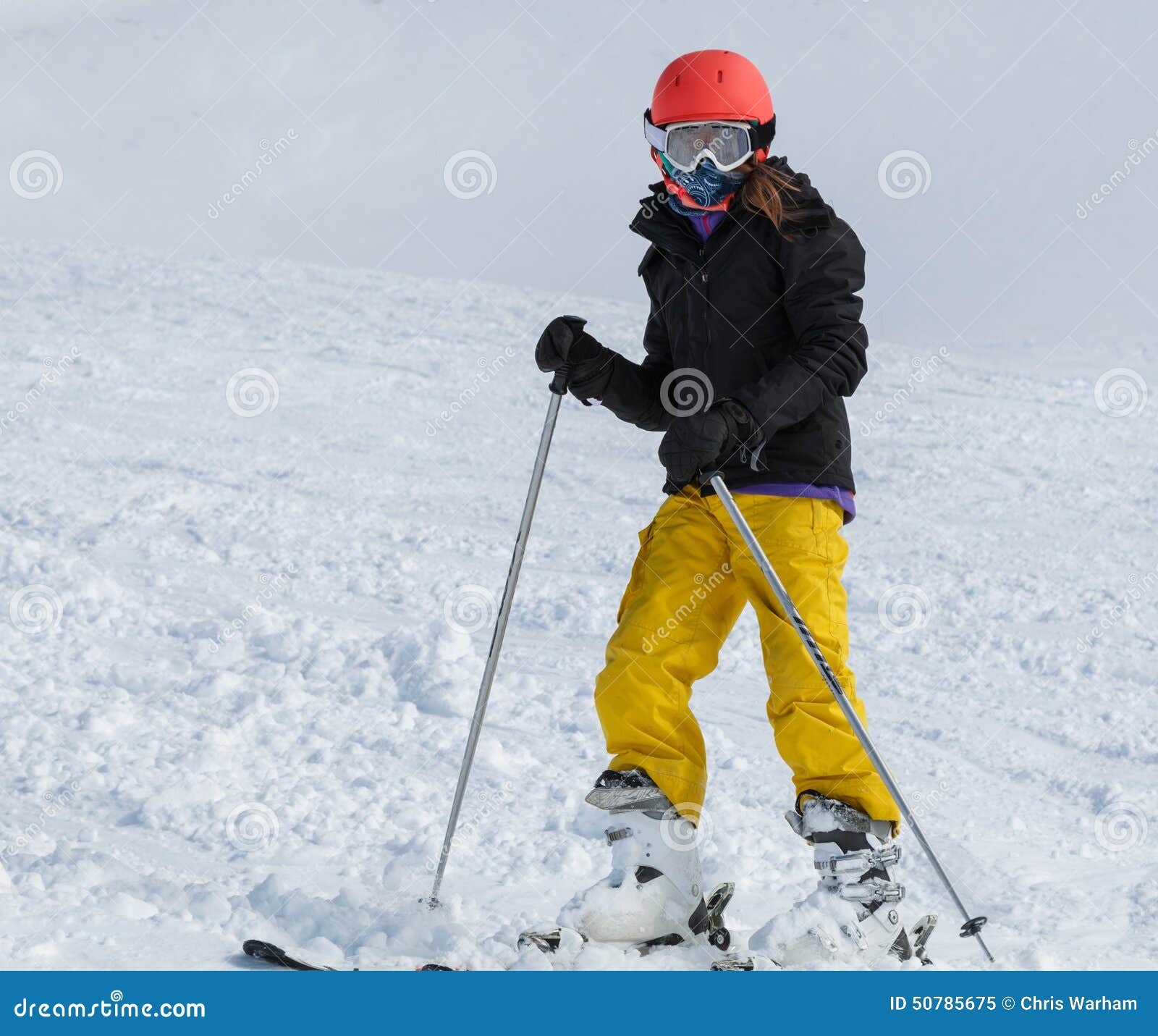 Young Girl (9-11) Skiing in Bright Yellow Pants with Orange Helm Stock ...