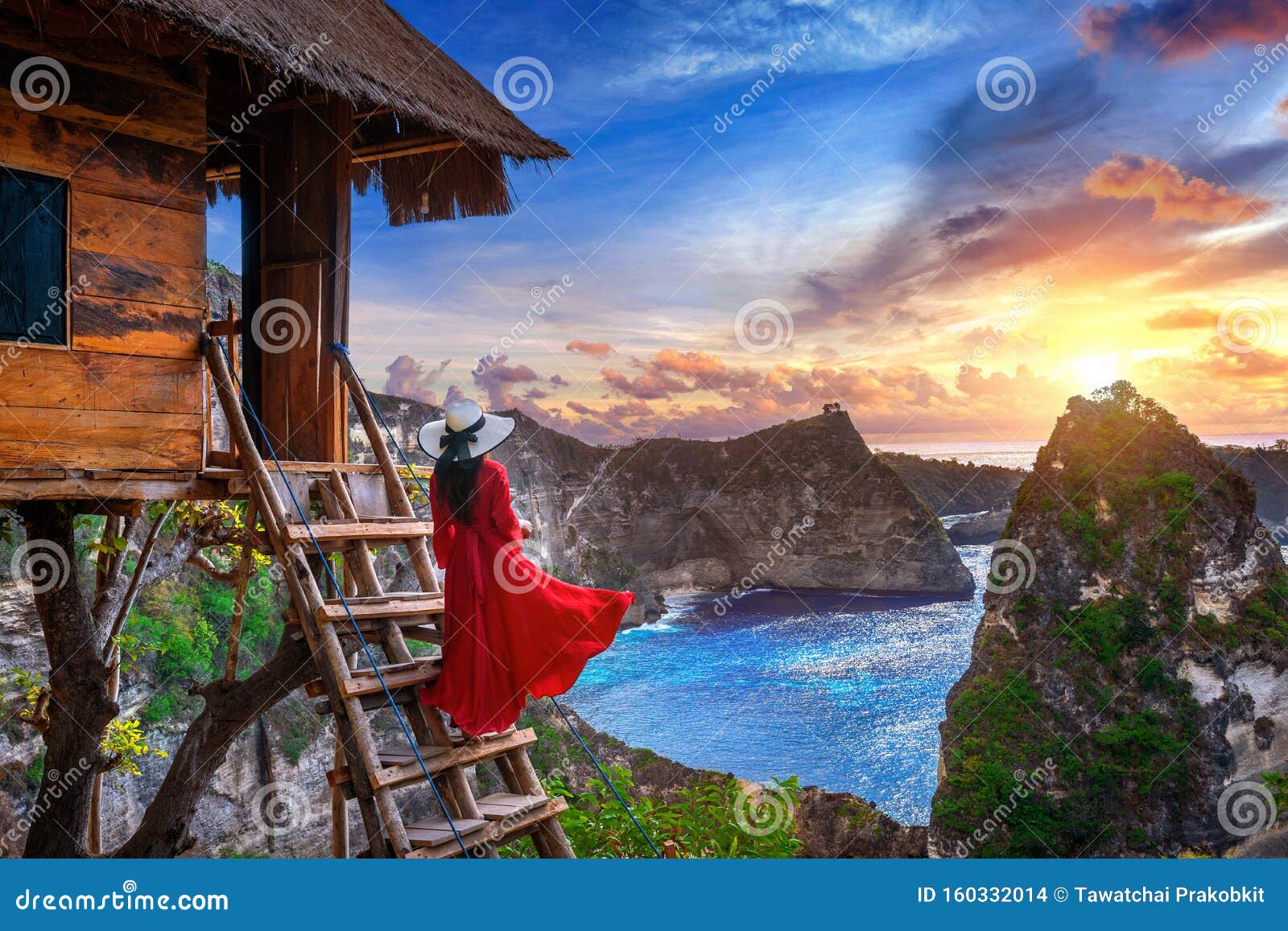 young girl on steps of house on tree at sunrise in nusa penida island, bali in indonesia