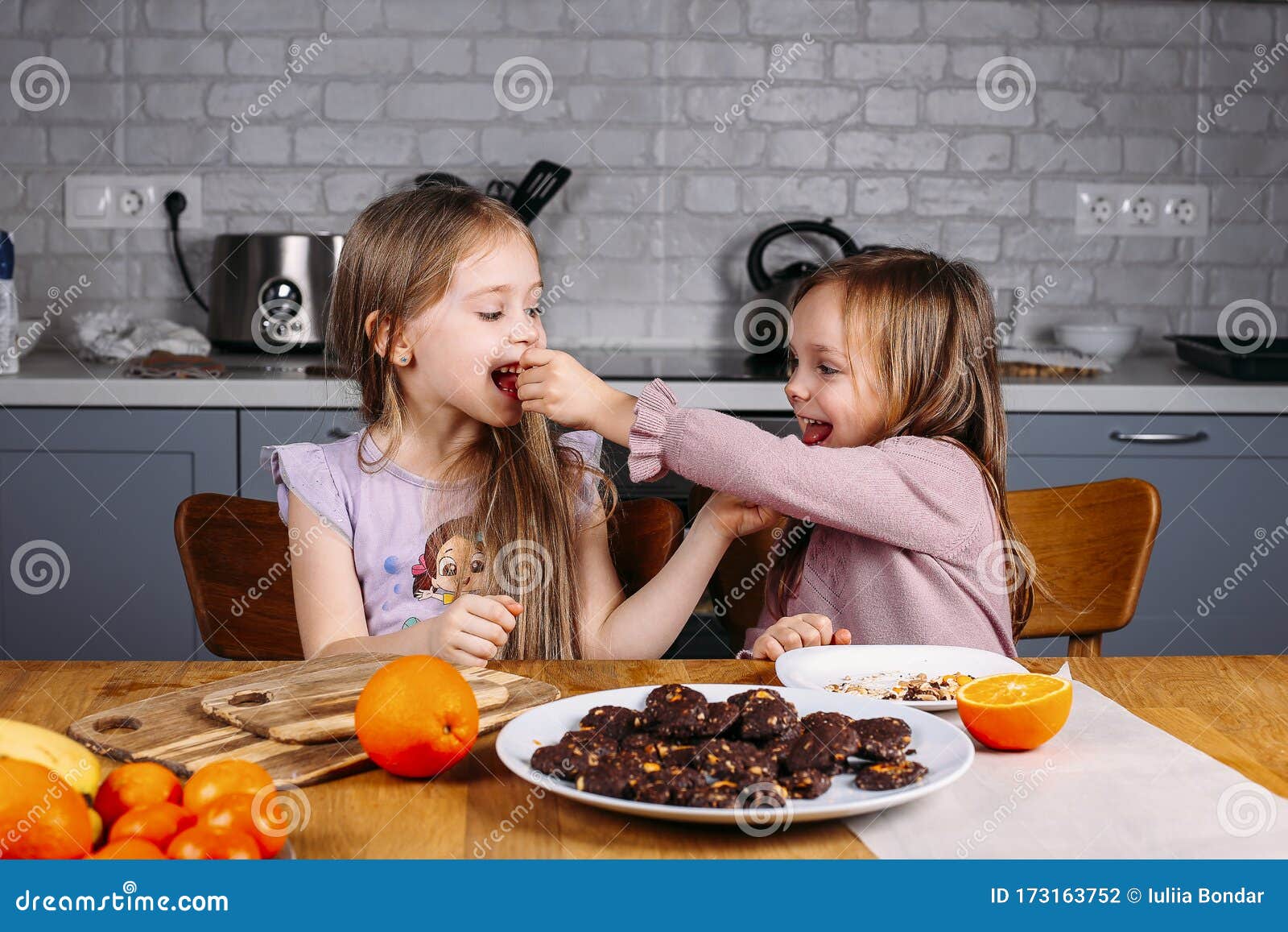 young girls eating biscuits at home