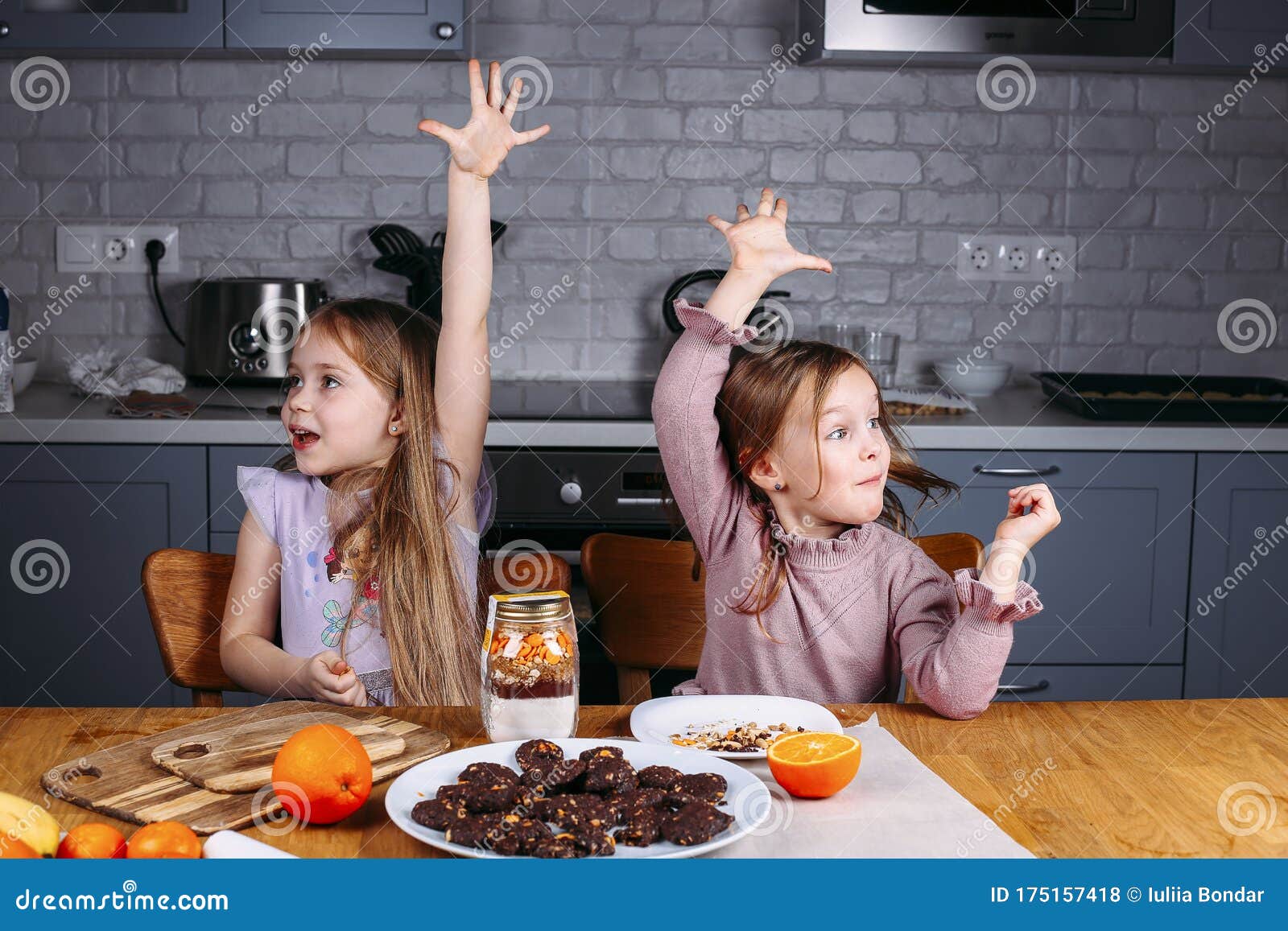 young girls eating biscuits at home
