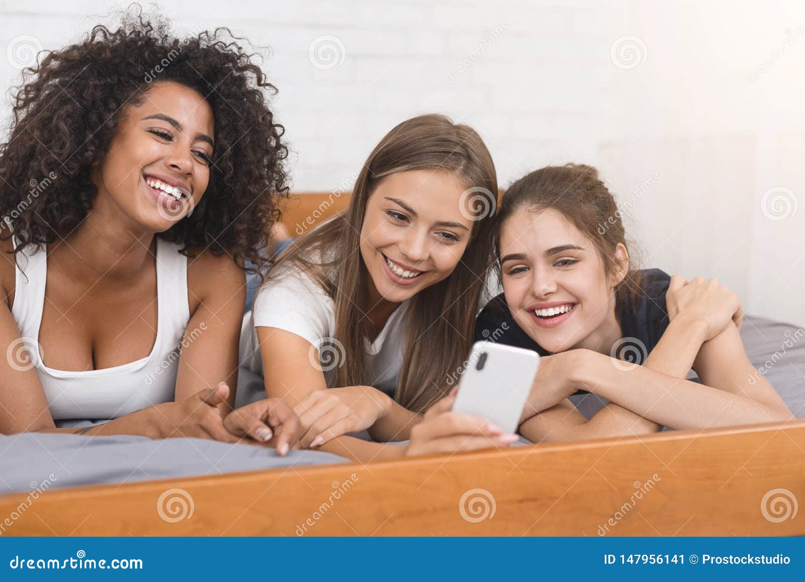 Young Girls Making Selfie, Lying on Bed with Smartphone Stock Image