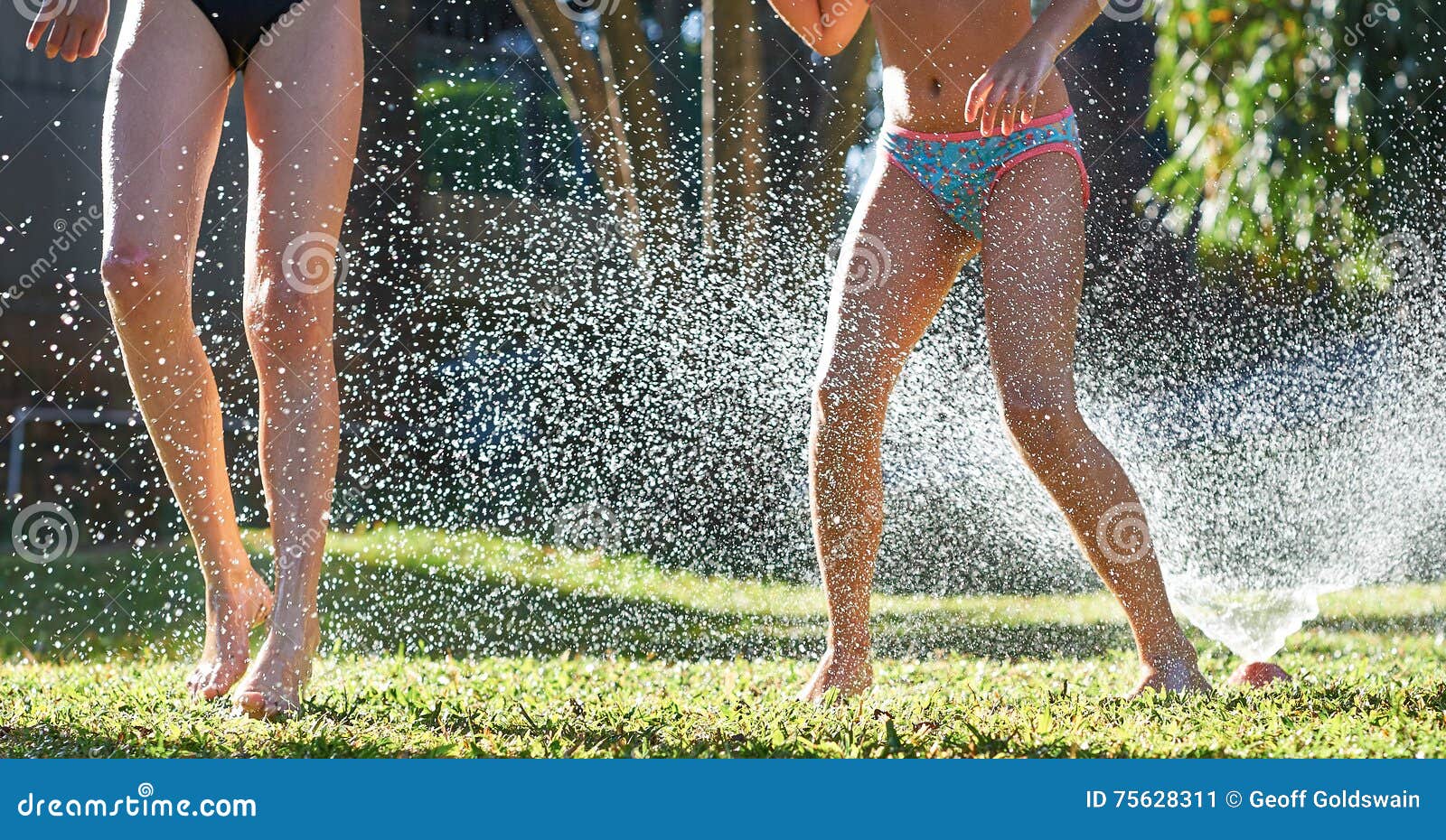 Young Girls Playing Jumping In A Garden Water Lawn 