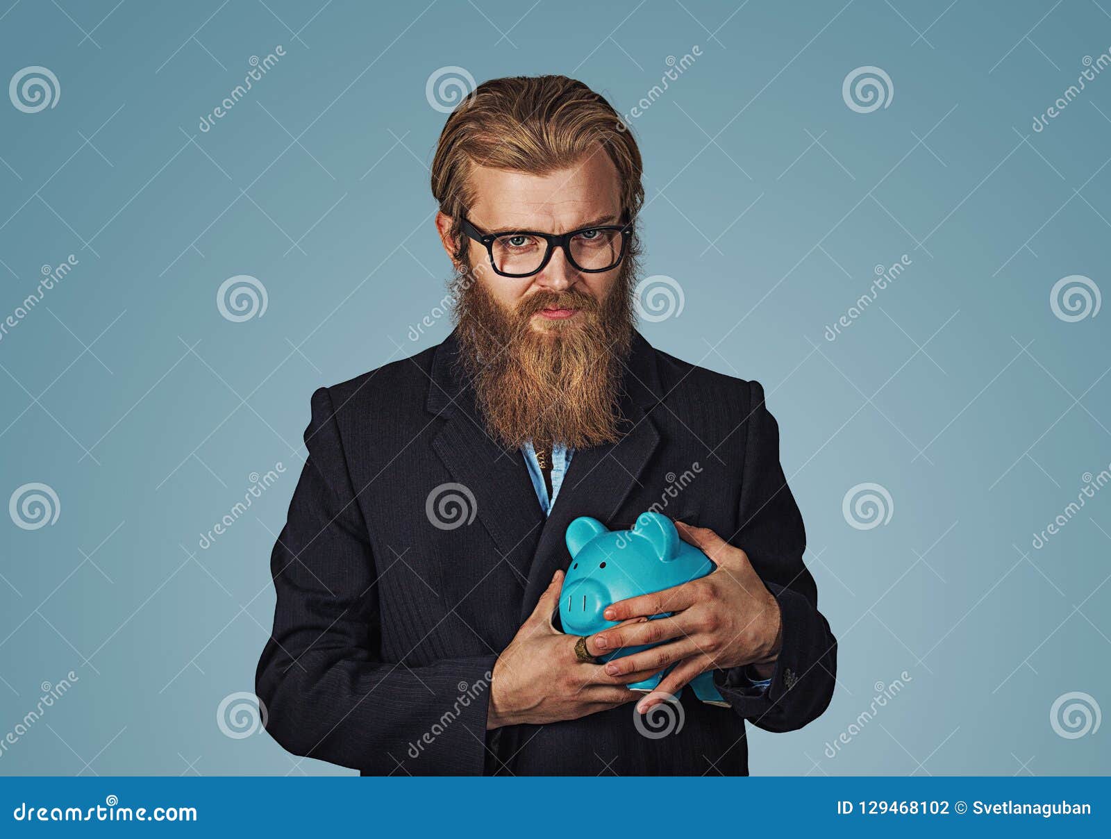 young greedy stingy business man holding piggy bank