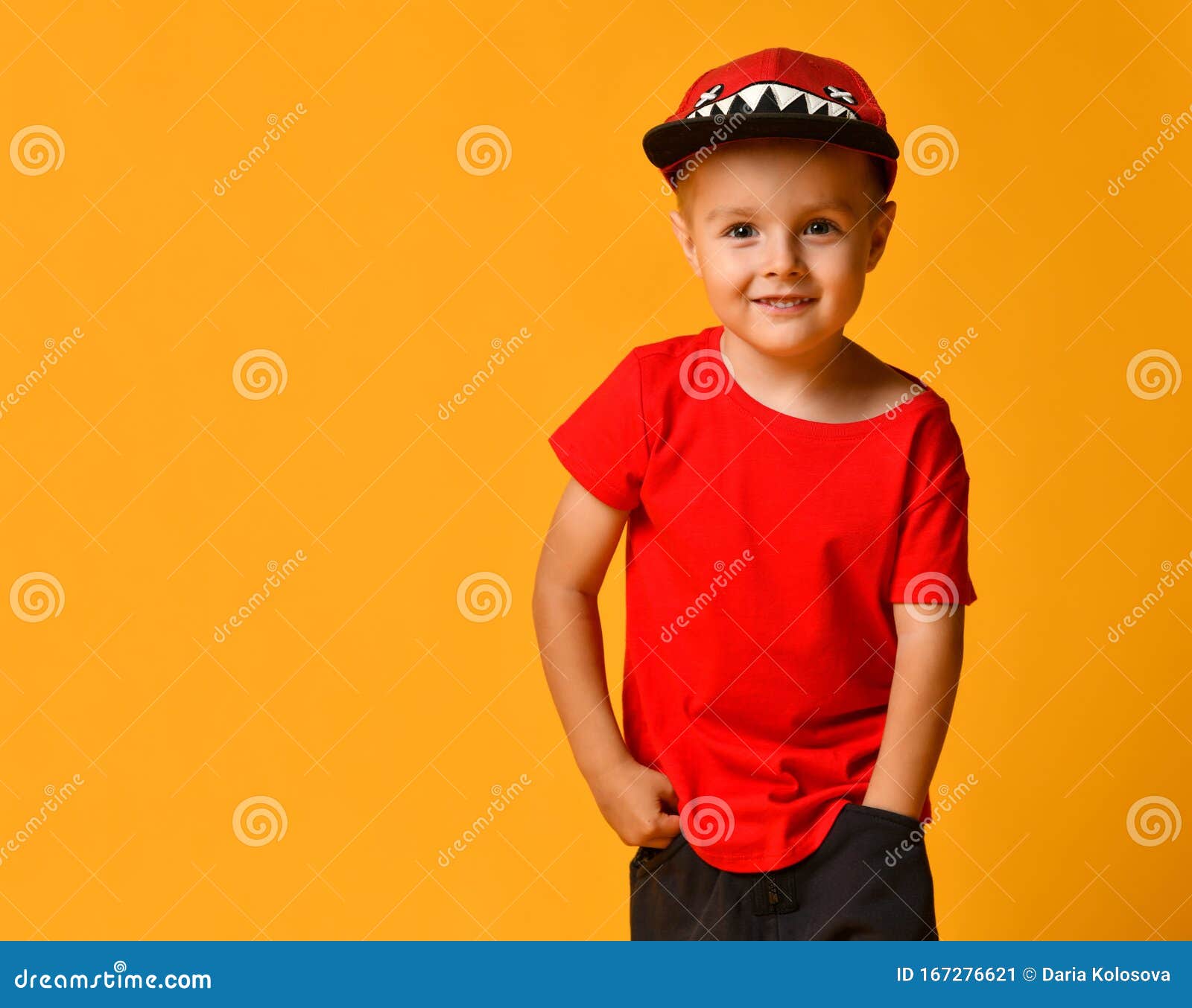 Young Boy in a Red T-shirt and Dark Pants, White Sneakers and a Cap Posing on a Copy Space on a Yellow Background Stock Image - of contemporary,