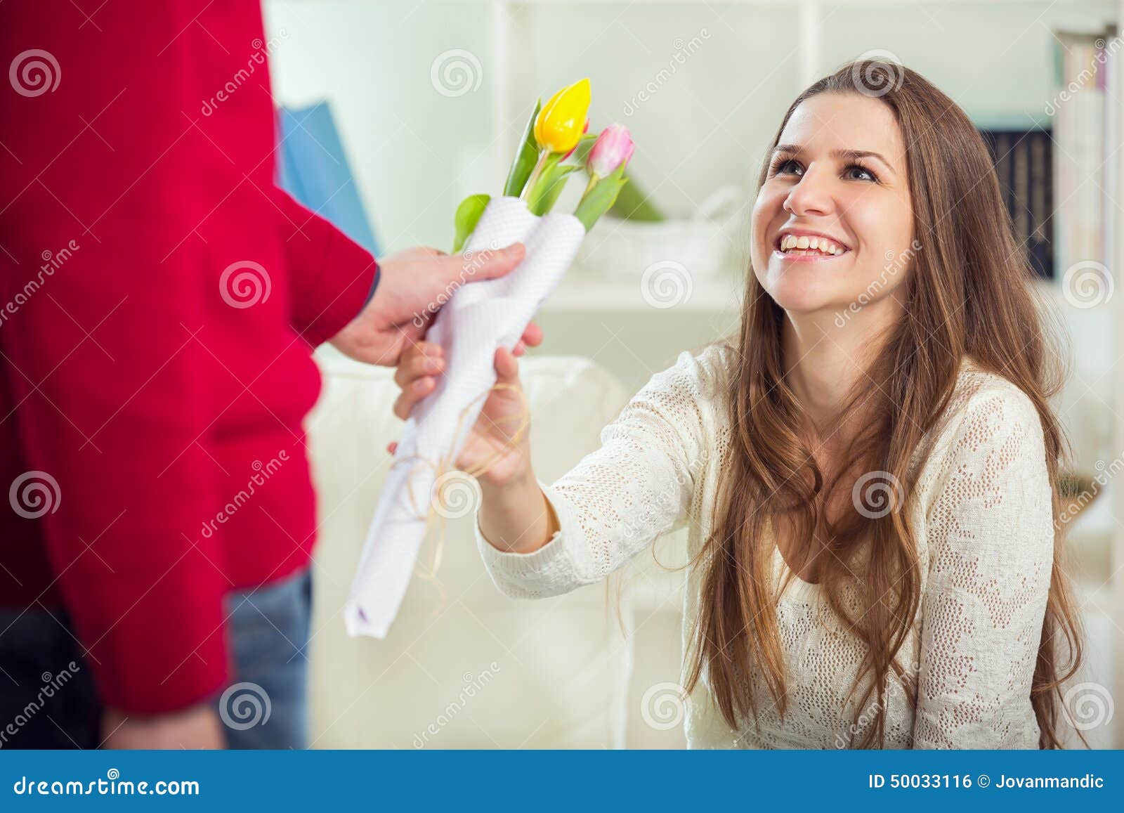 Young Guy Brings Flowers To His Girlfriend. Stock Photo Image of gift