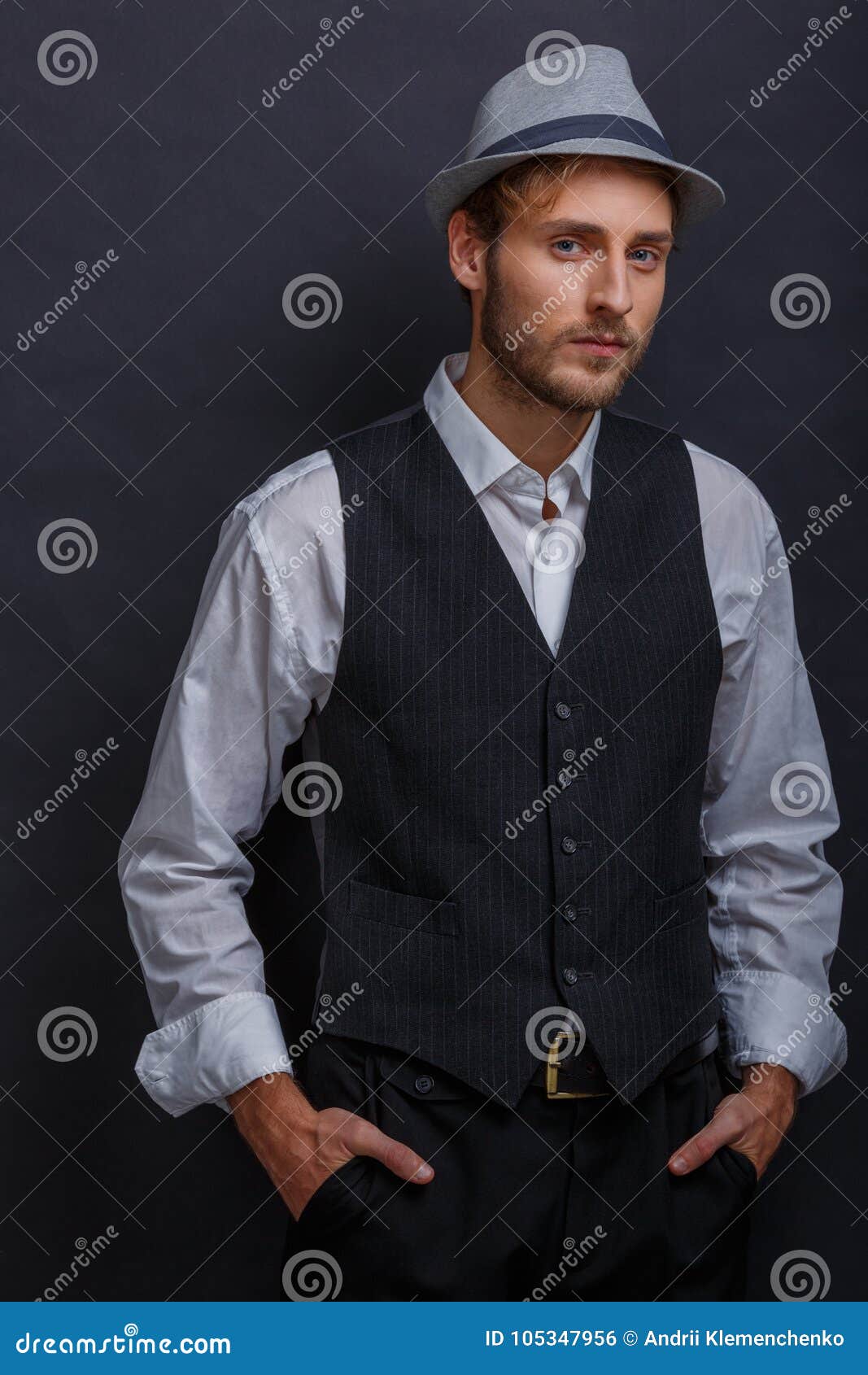 A Guy in a Suit with a Vest and in a Hat Posing while Standing, Holding ...