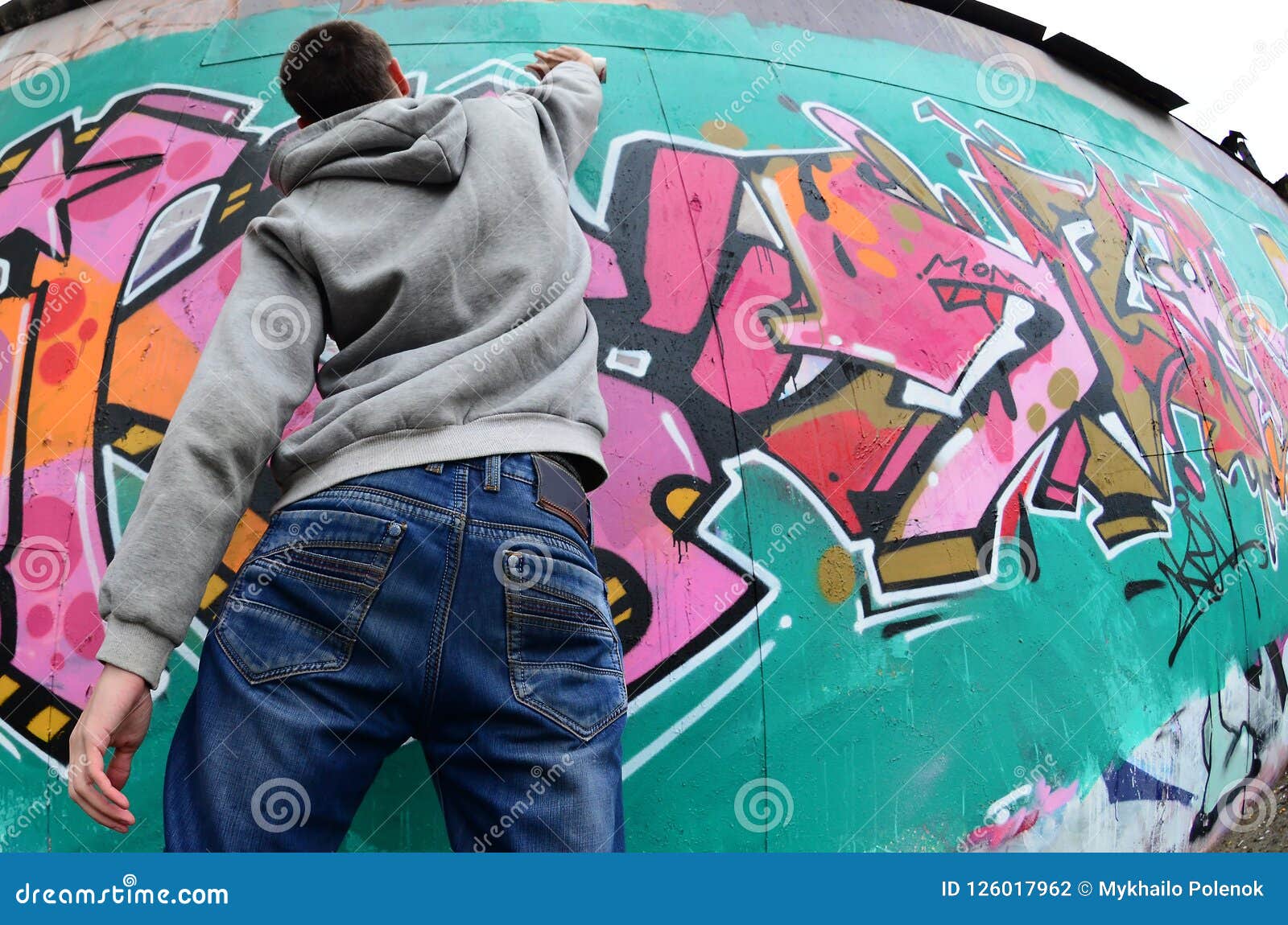 A Young Guy in a Gray Hoodie Paints Graffiti in Pink and Green C Stock ...