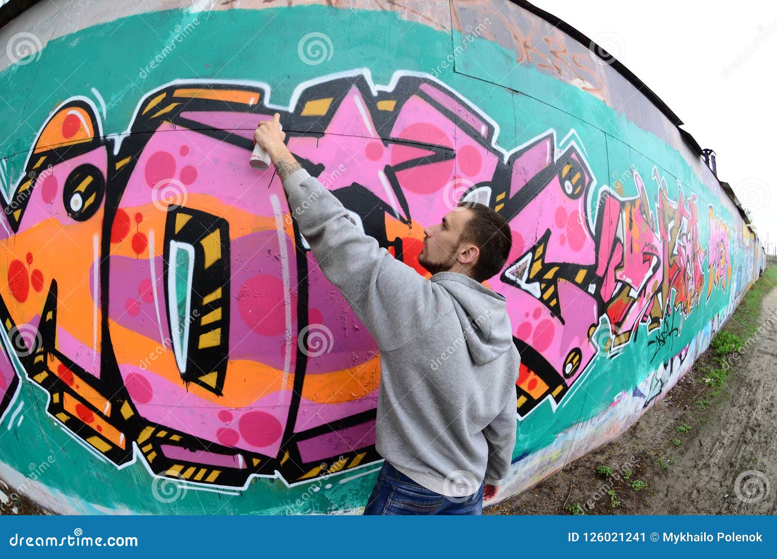 A Young Guy in a Gray Hoodie Paints Graffiti in Pink and Green C Stock ...