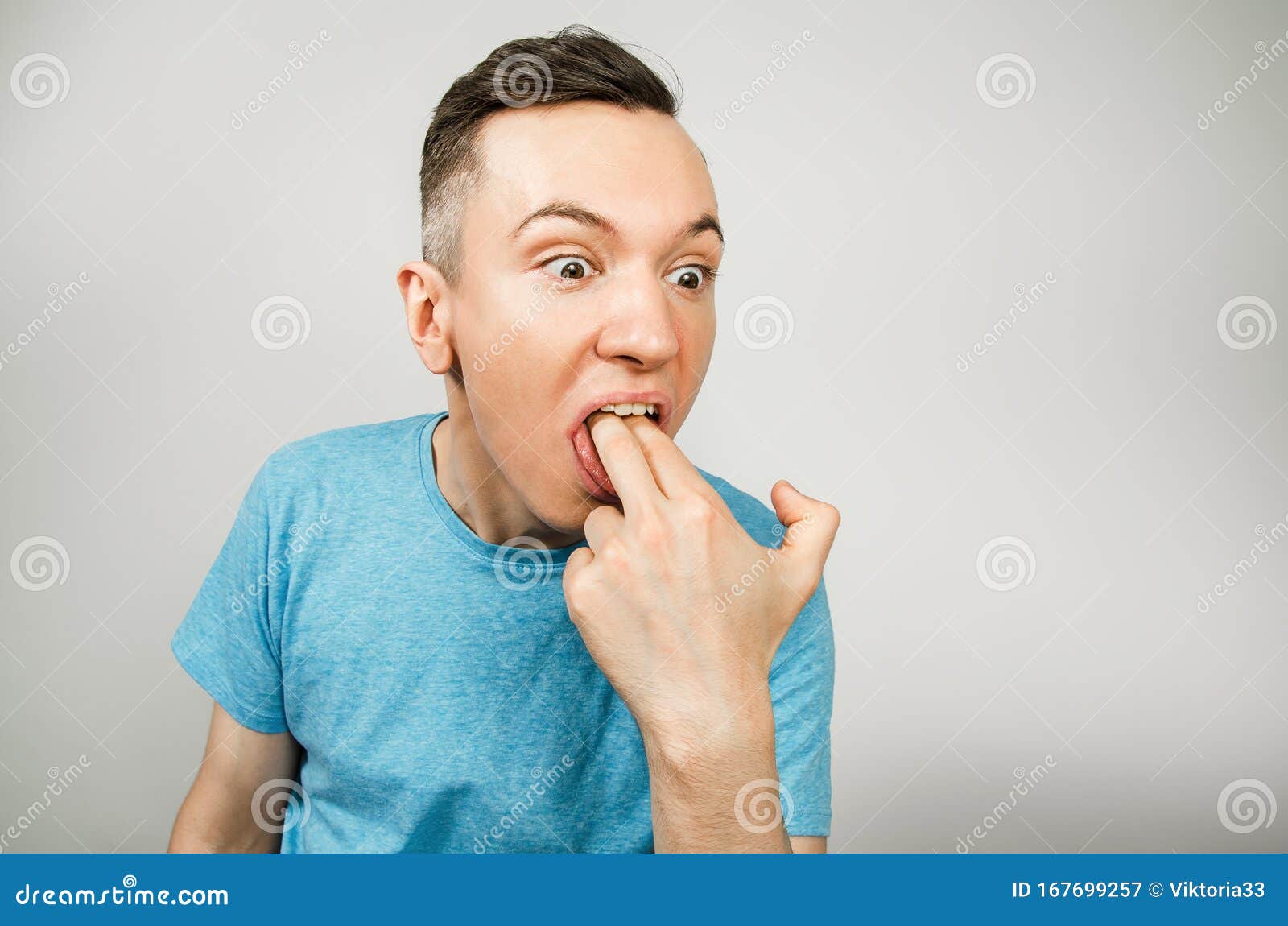 Young Guy Inserts Two Fingers in the Mouth To Induce Vomiting, on a Light Background Stock Image