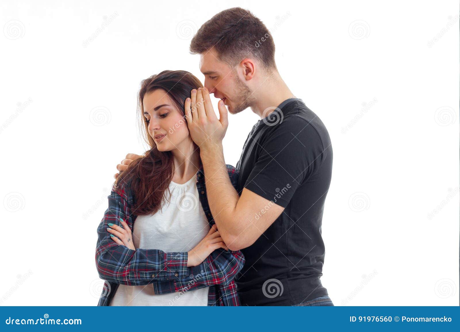 Young Guy Says Something To the Girl in Her Ear and she is Smiling Stock Photo