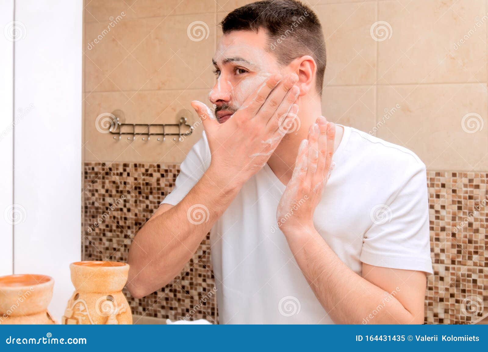 a young guy washing his face with gel. personal care.
