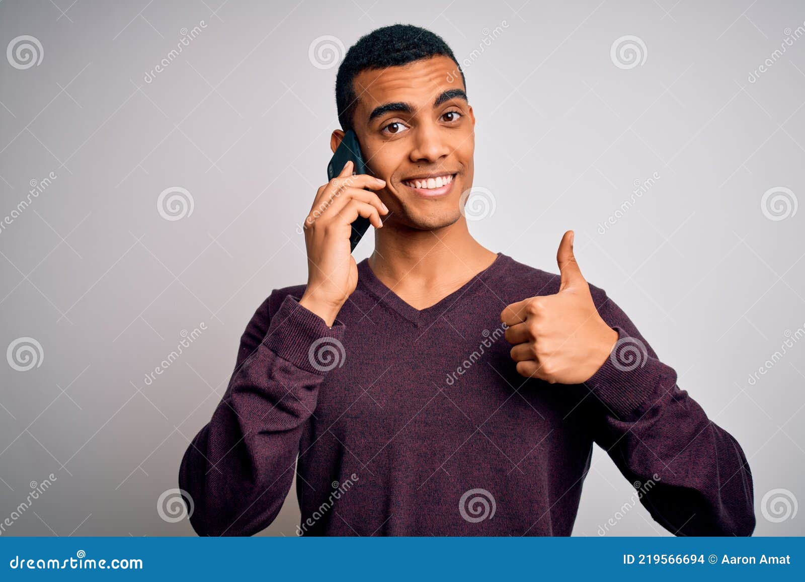 Young handsome african american man having conversation talking on the smartphone happy with big smile doing ok sign, thumb up