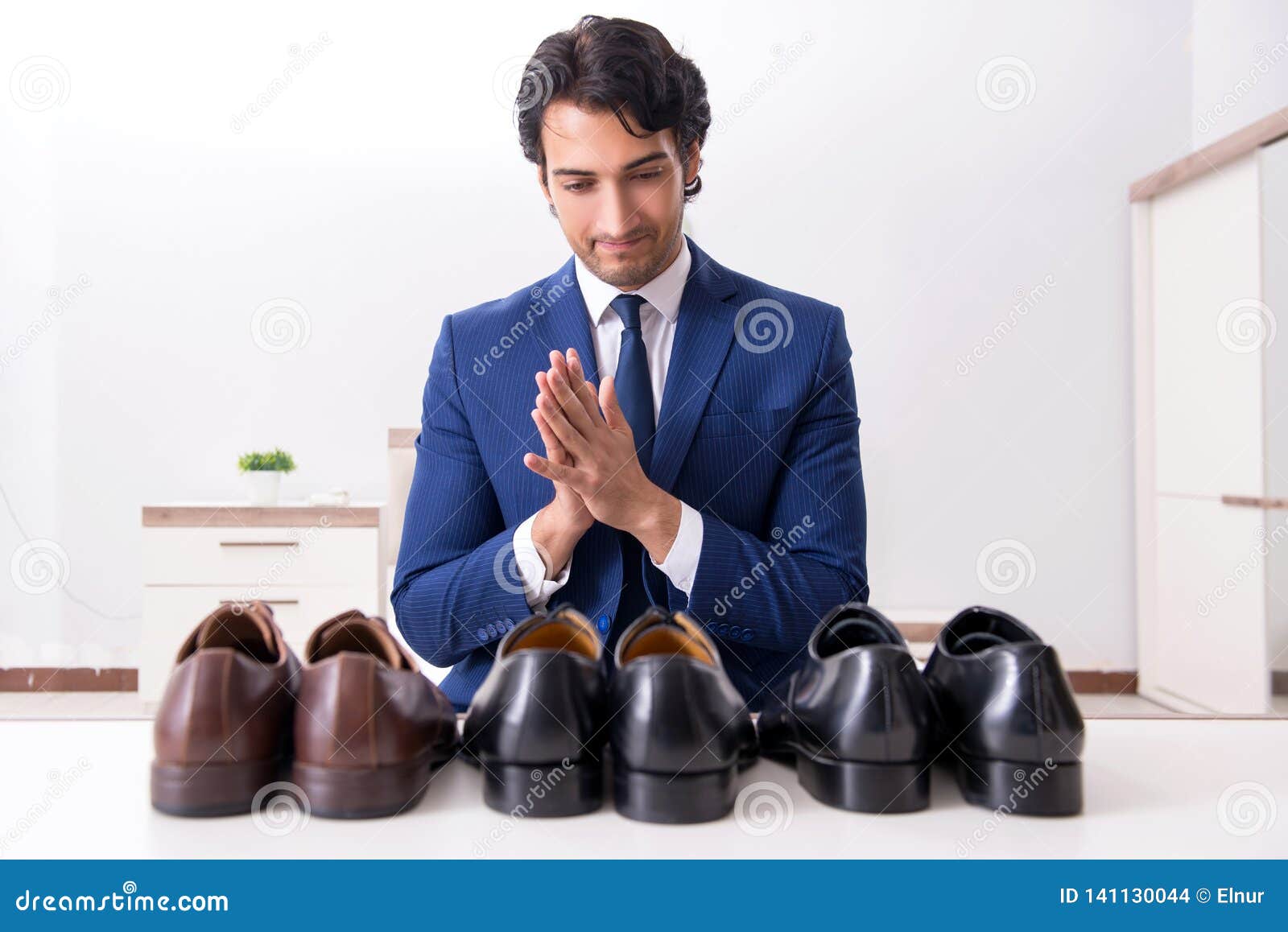Мужчина выбирает обувь. Люди в обуви. Переодевает обувь. Мужчина с обувью в руках. Обувной для мужчин.